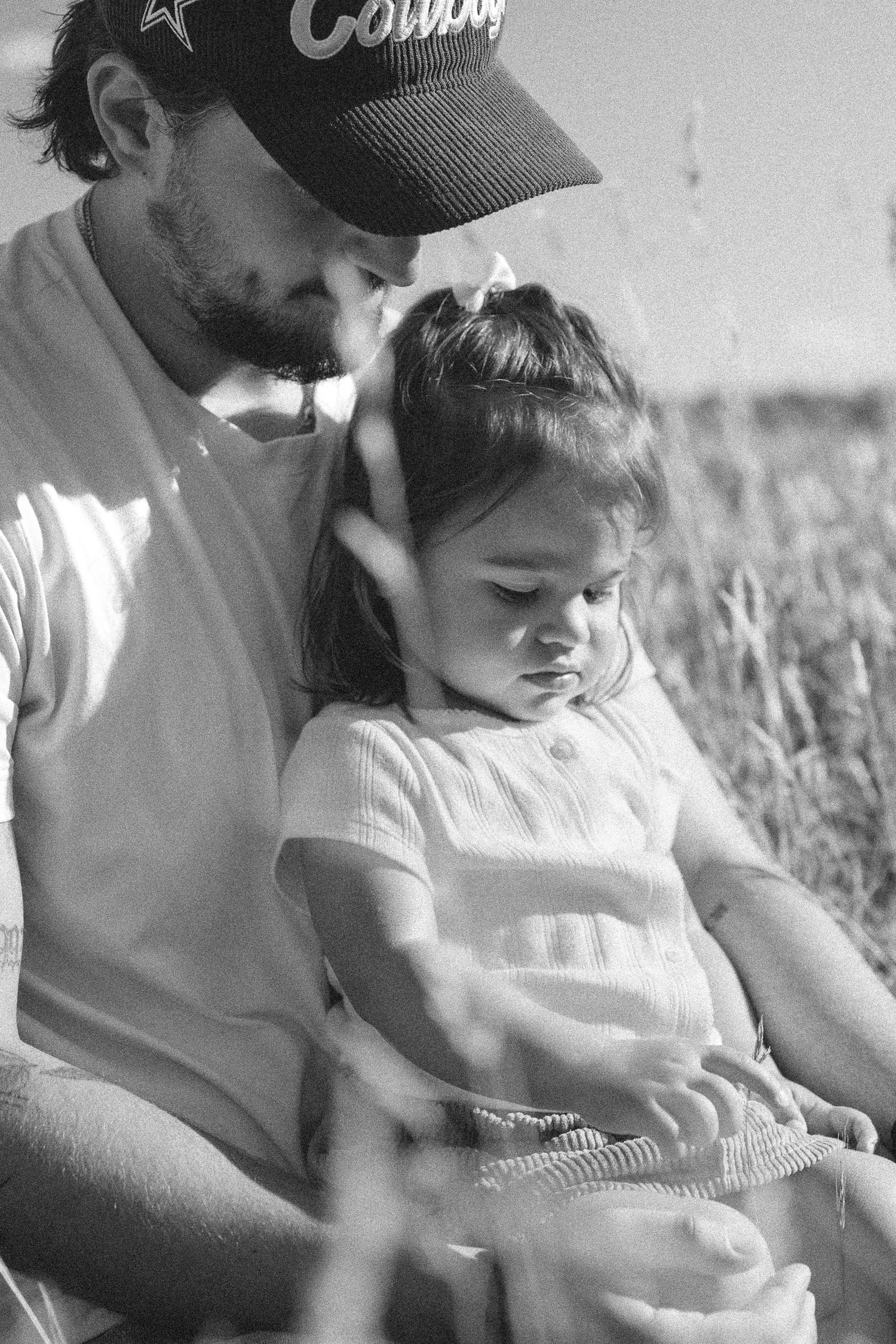 Black and white candid moment shared in a grassy field.