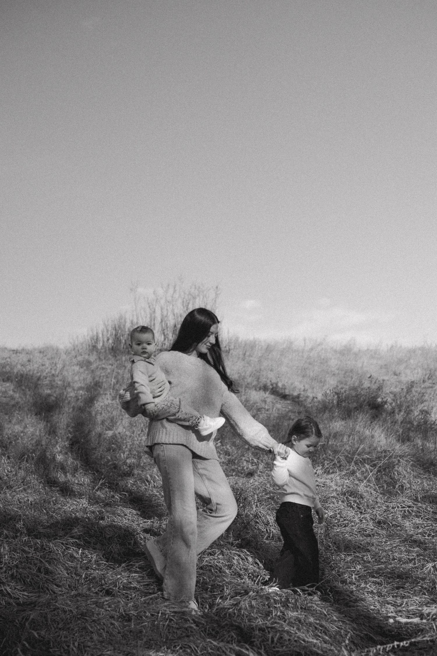 Series of black and white photos showing playful moments in a grassy field.