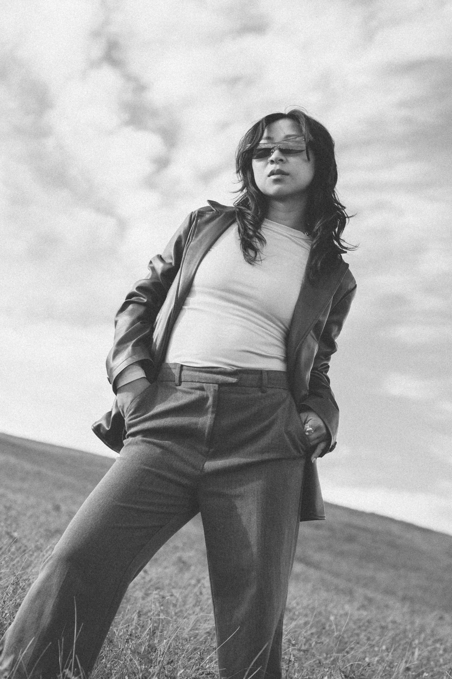 A monochrome fashion shot featuring casual wear against a cloudy sky.