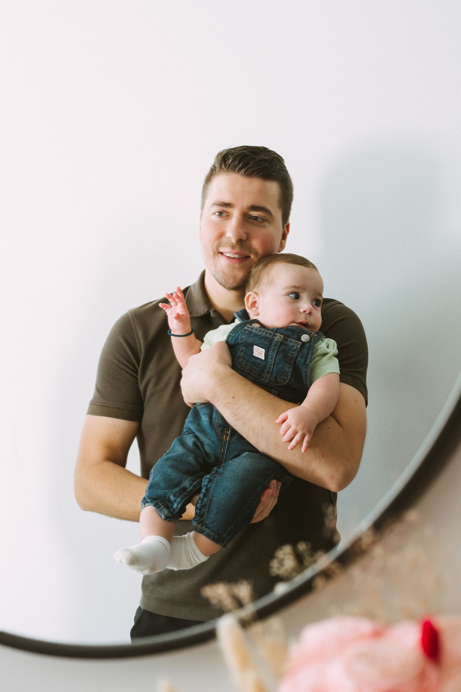 A parent and baby share tender moments together in a series of three candid photos against a white wall.