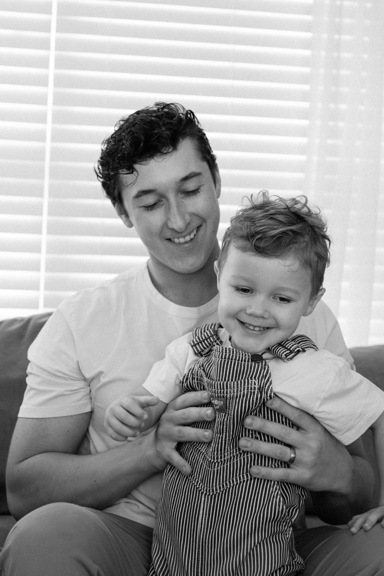 Black and white series of candid moments showing joyful interaction and laughter on a couch.