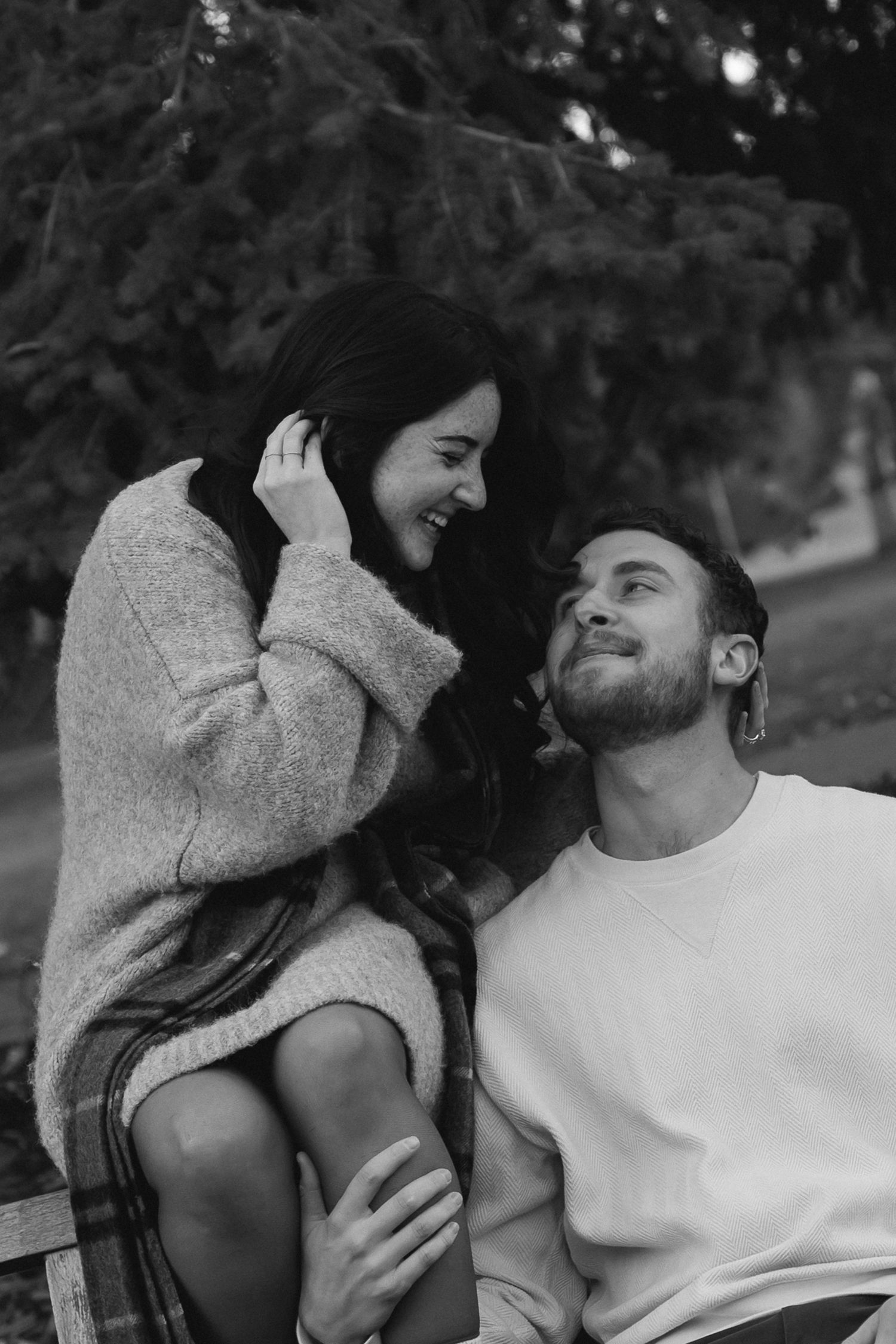 A tender black and white photograph captures a couple embracing on a winter evening.