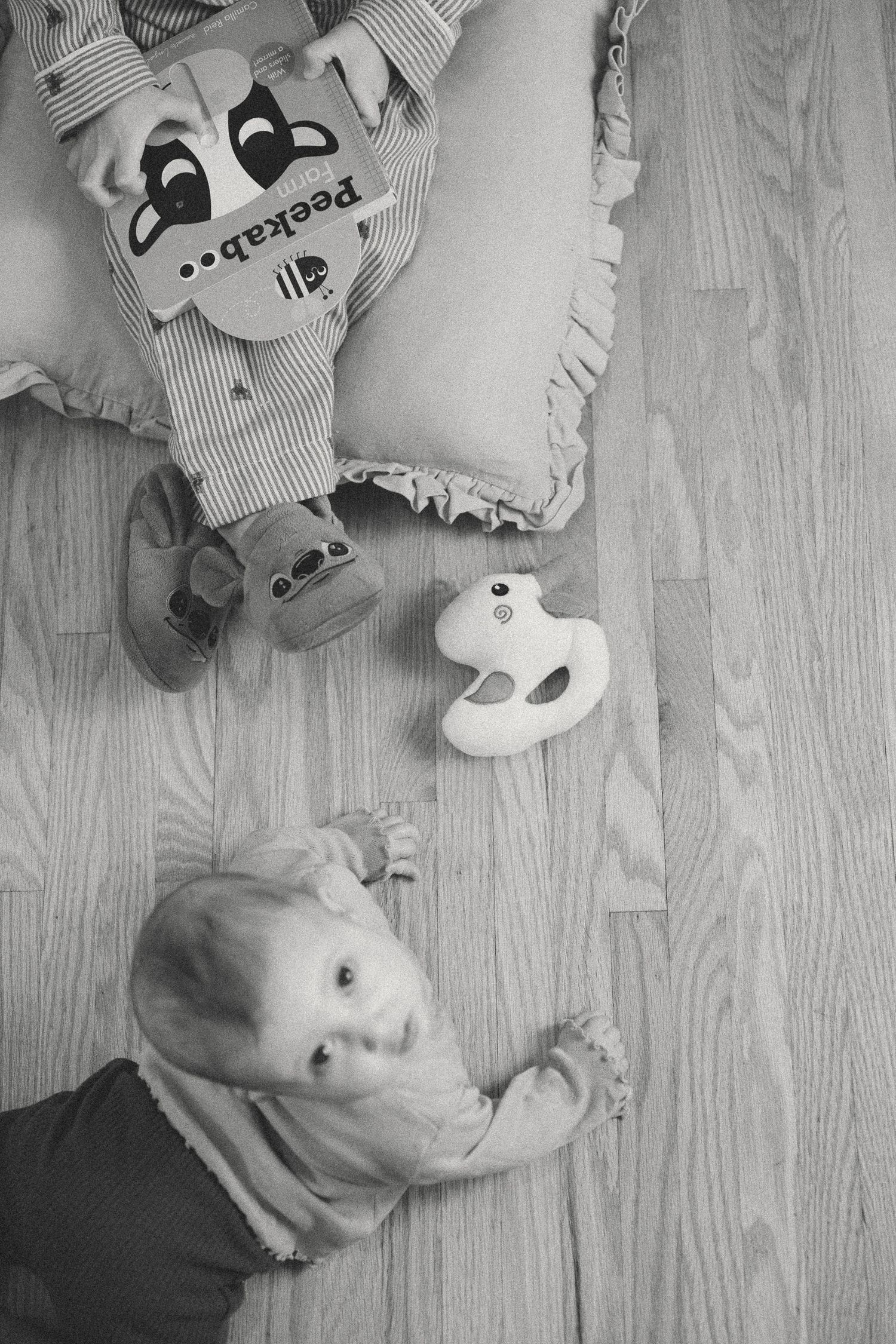 Black and white overhead shot of playtime on wooden floor.