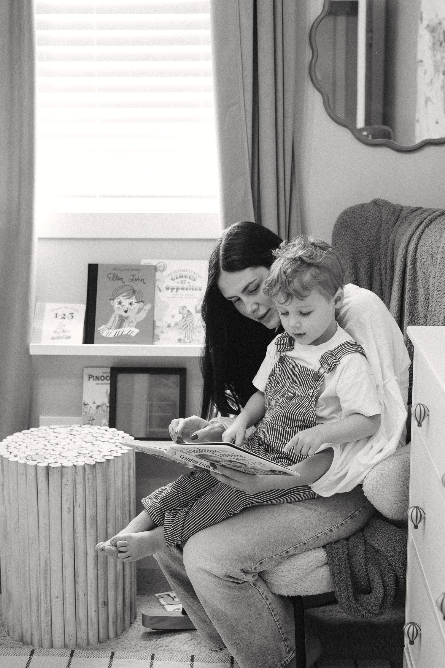 People sit together reading books in a black and white photograph showing a quiet moment of shared literacy.