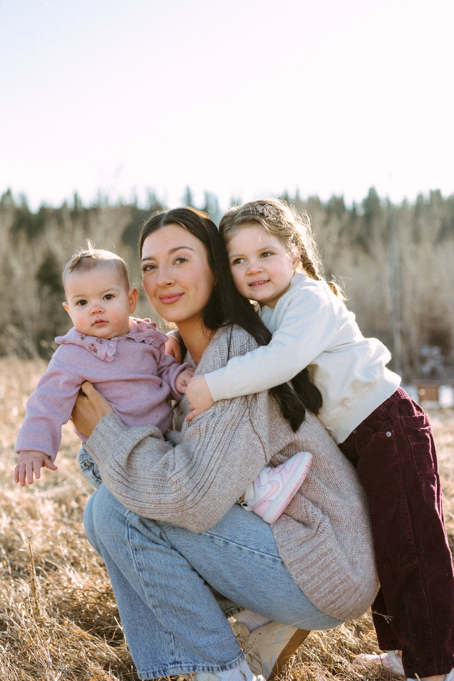 A series of outdoor family portraits showing tender moments in a natural setting with golden sunlight and trees.