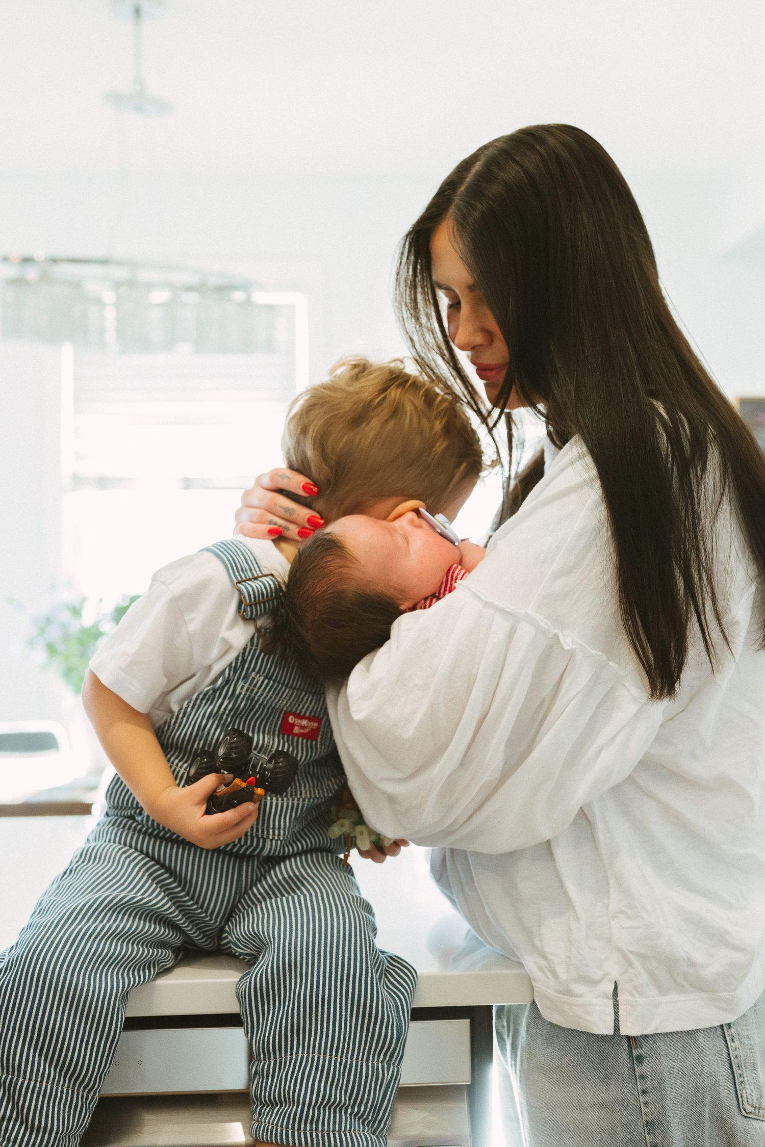 A series of playful moments showing a child in striped overalls interacting with someone in a white shirt.