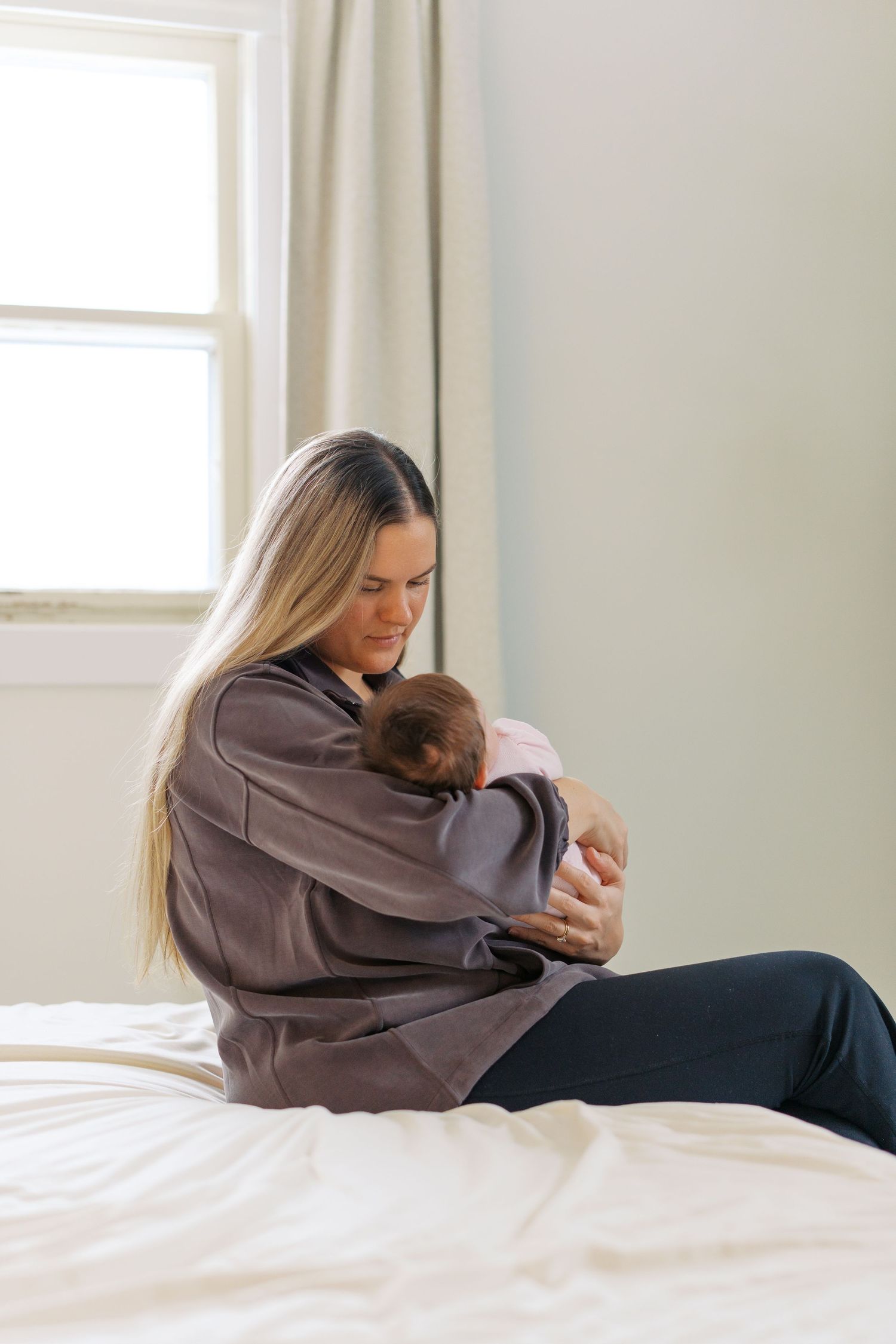 Peaceful moment between parent and child resting on white bedding.