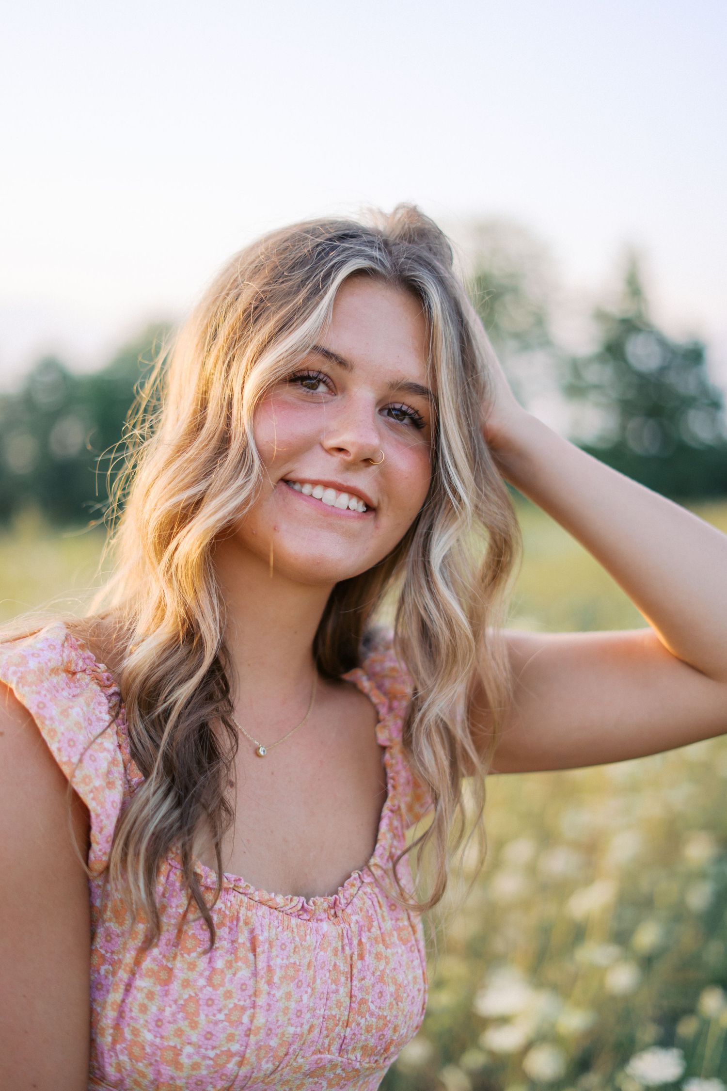 Outdoor portrait with natural lighting and warm sunset glow in a summer meadow.