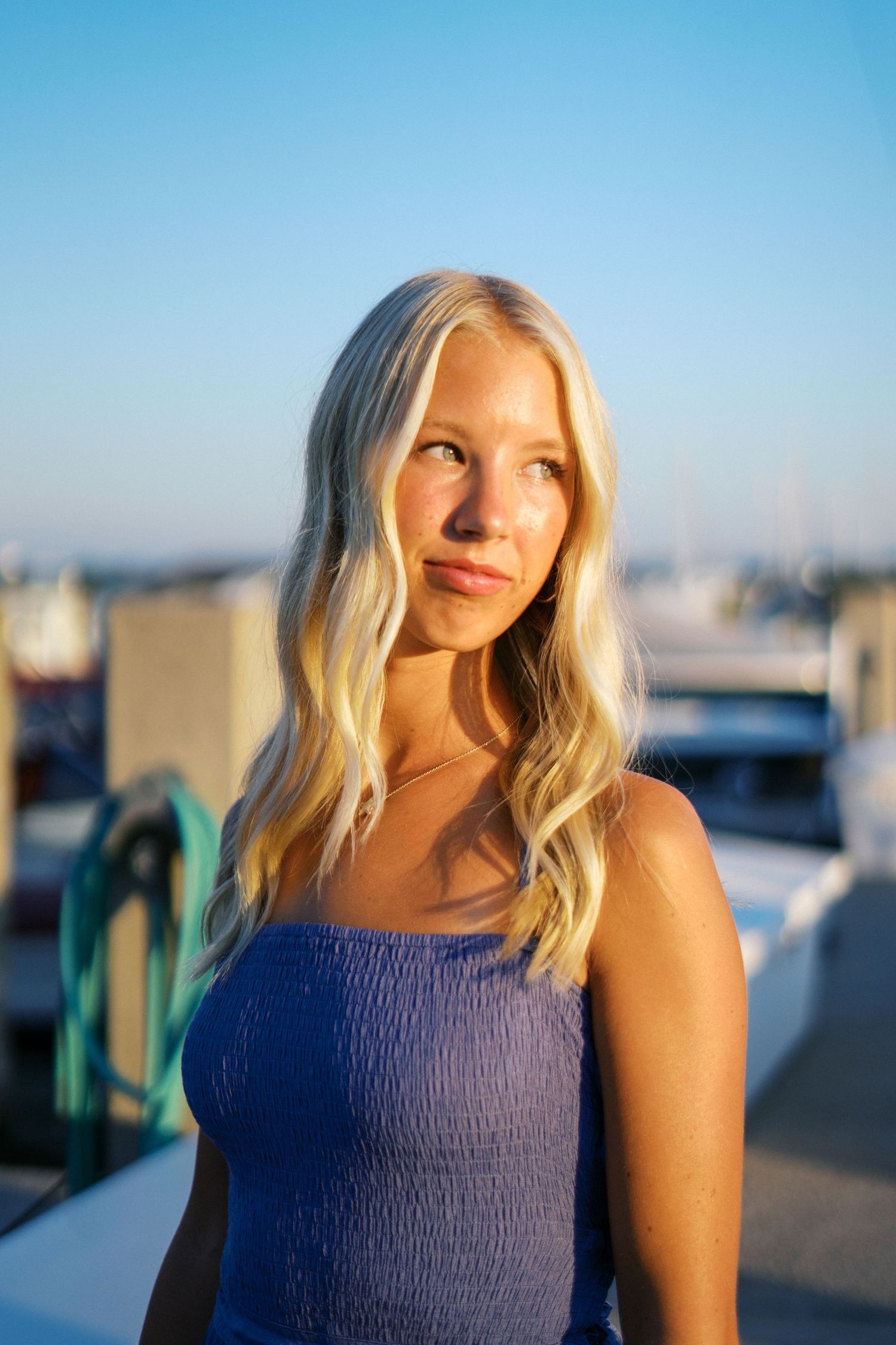Seaside portrait with blue dress against marina background.
