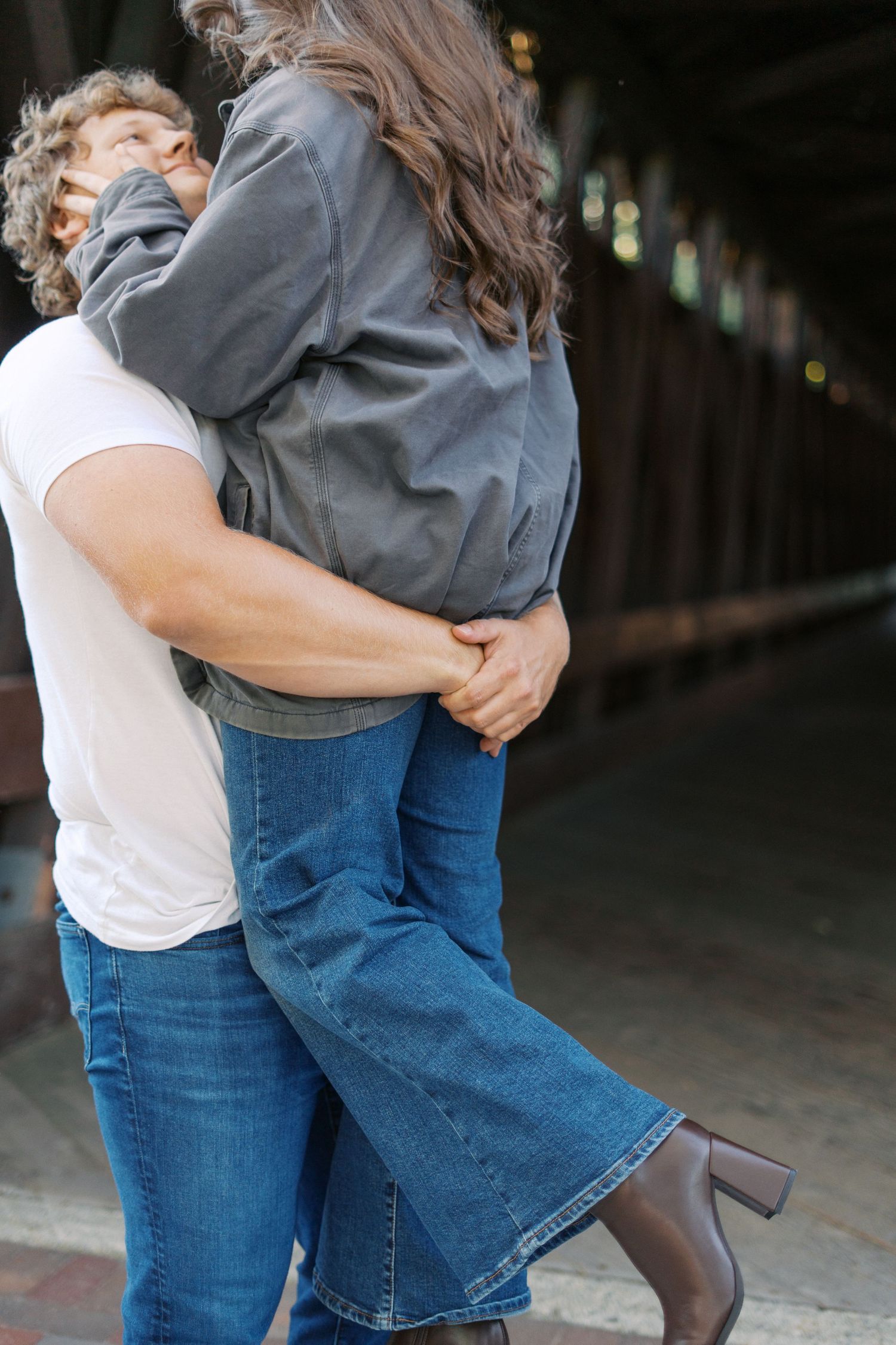 Couple in denim and casual wear sharing a romantic embrace.