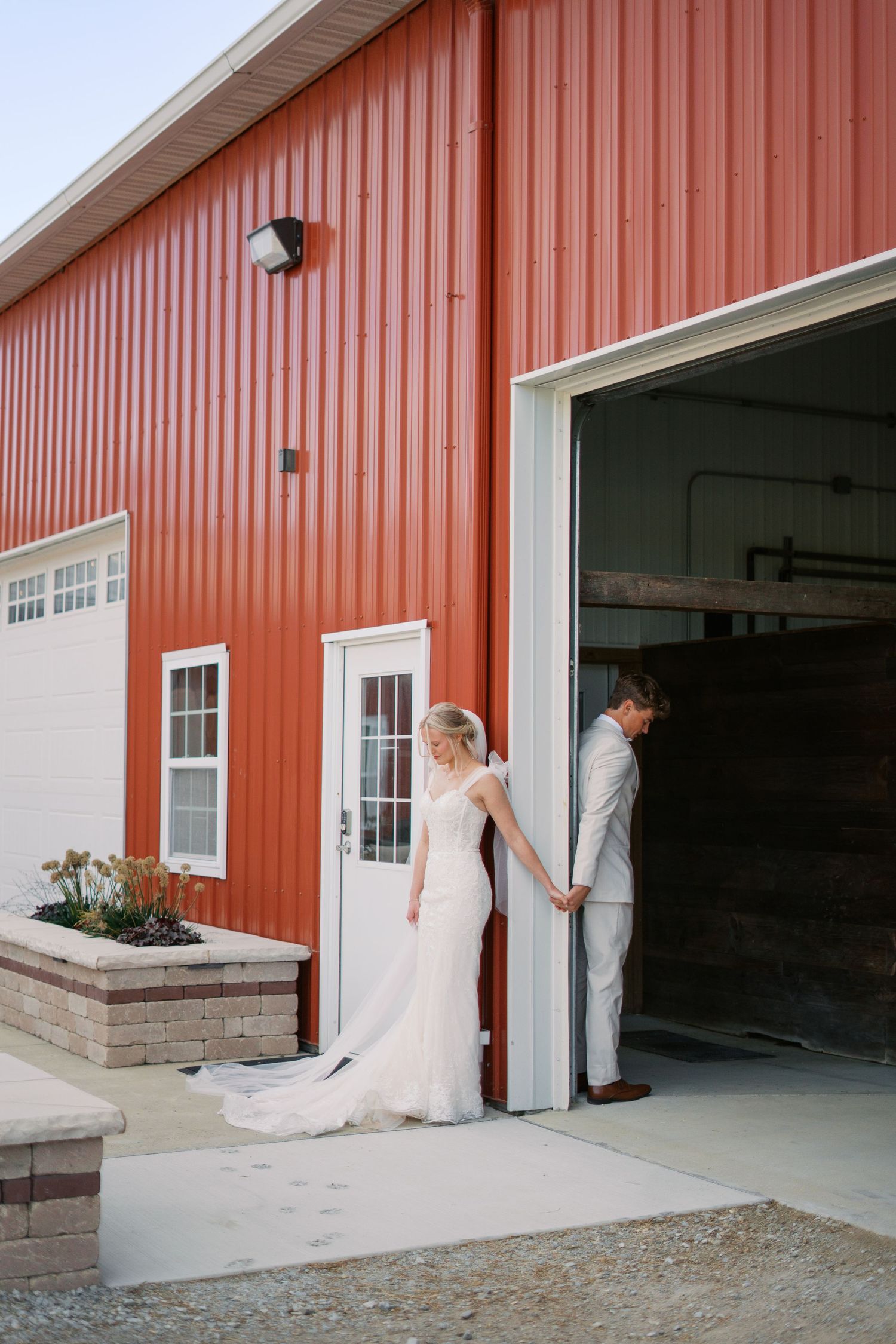 First look moment between couple outside red barn wedding venue.