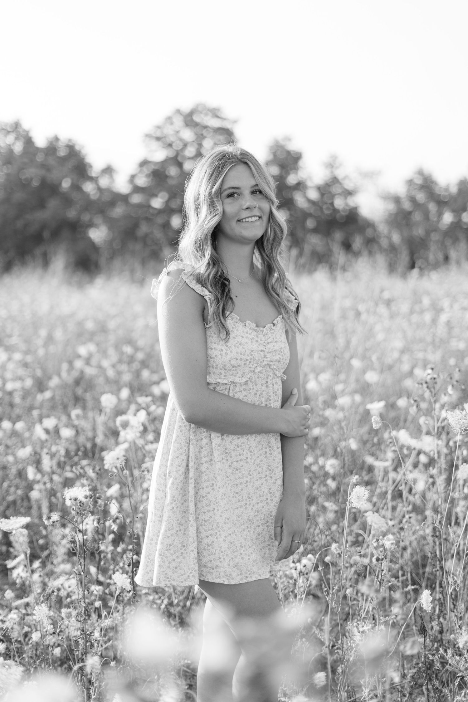 Black and white portrait in a blooming wildflower field with soft natural lighting.