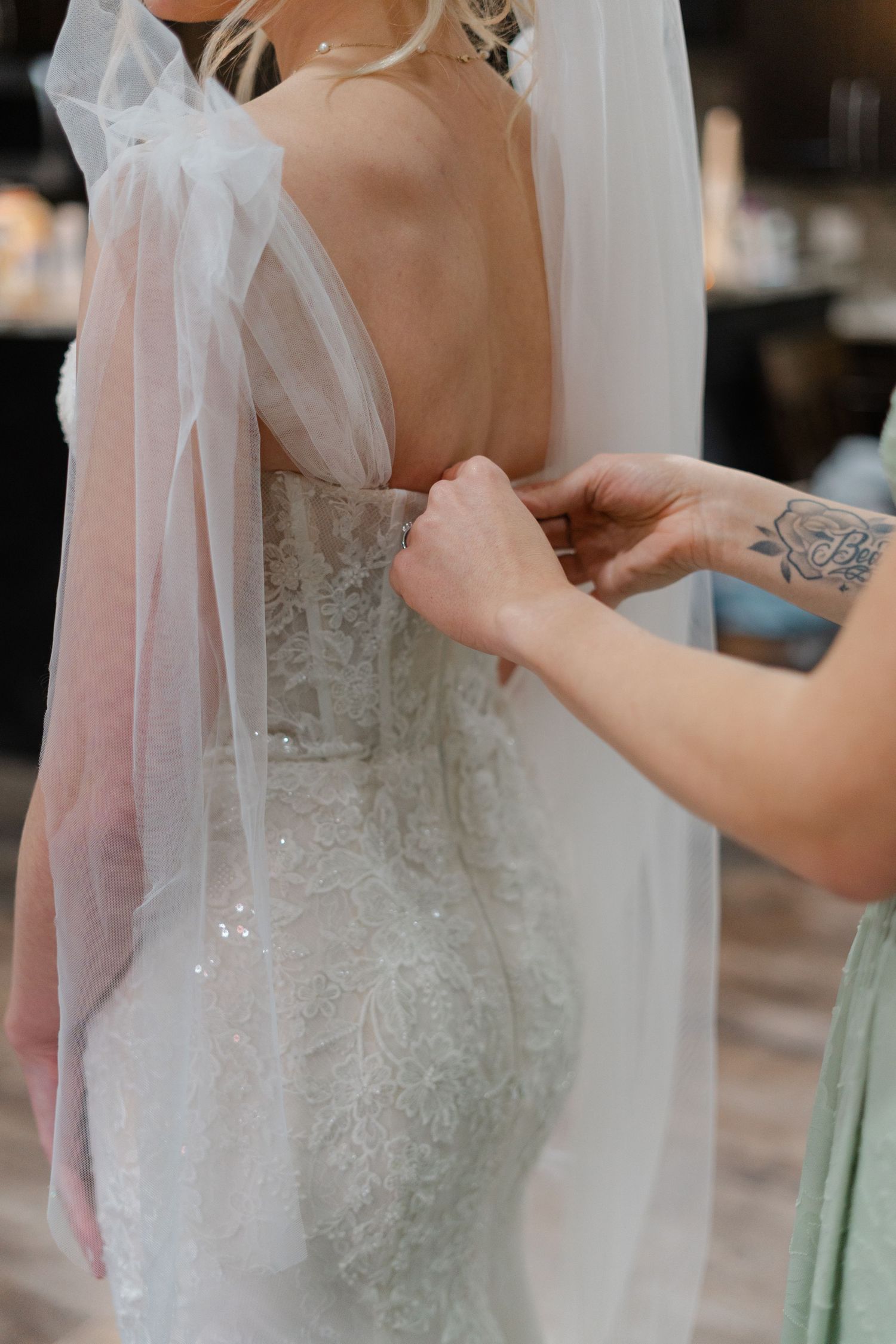 Close-up details of an intricate lace wedding dress with delicate beading and tulle veil.