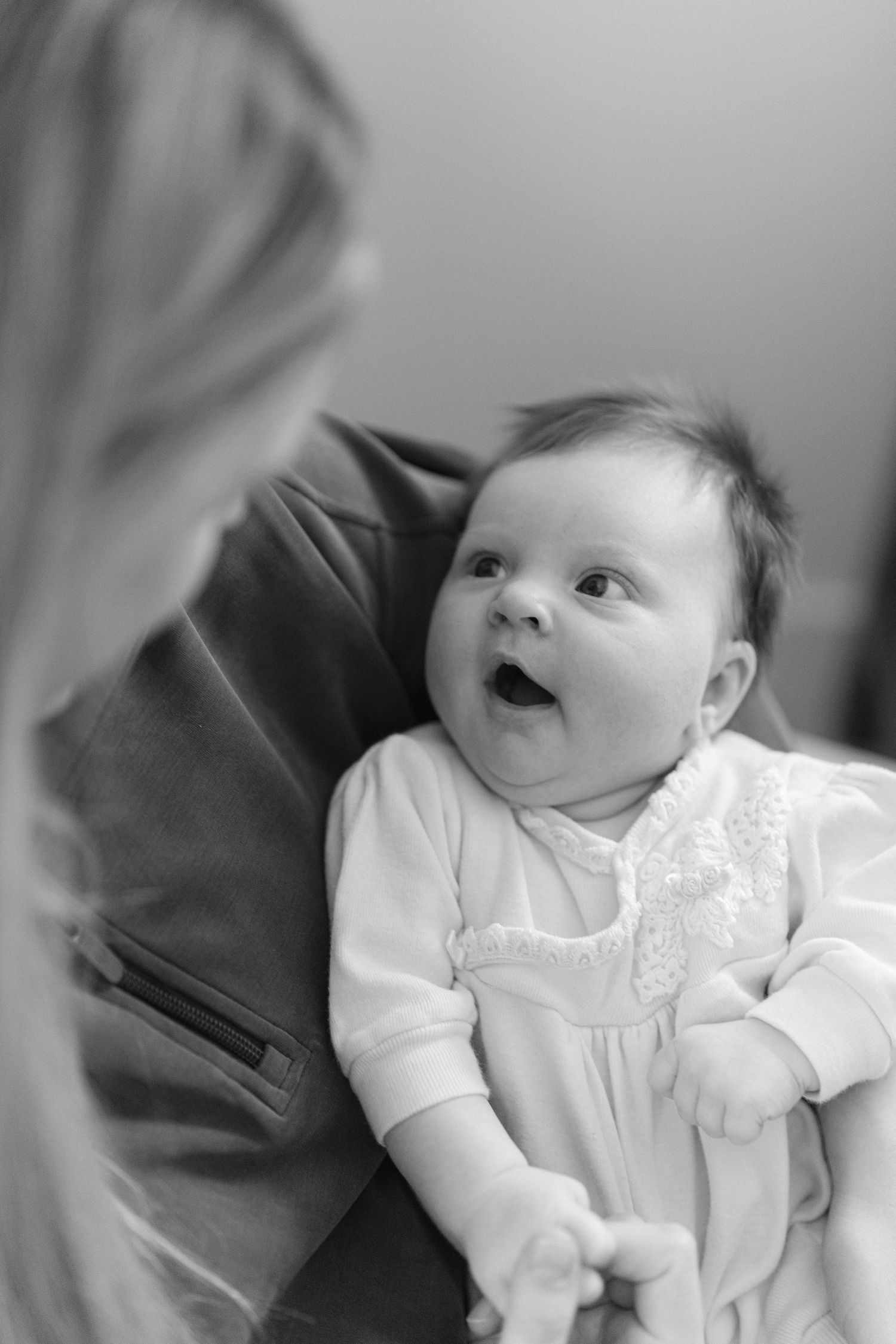 Baby wearing white dress outfit during indoor photoshoot.