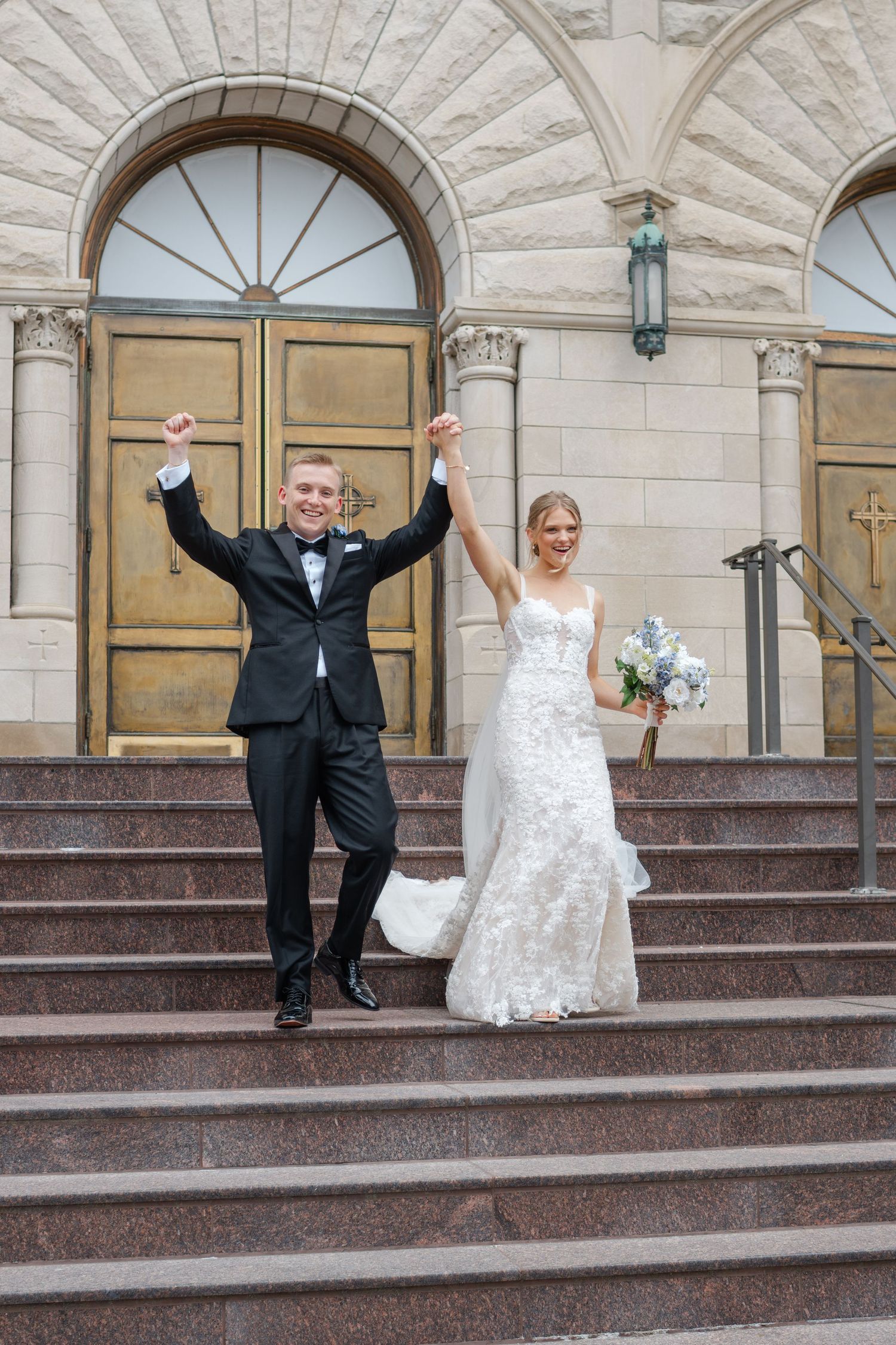 Joyful wedding photos on grand stone steps showing celebratory poses outside a historic building.