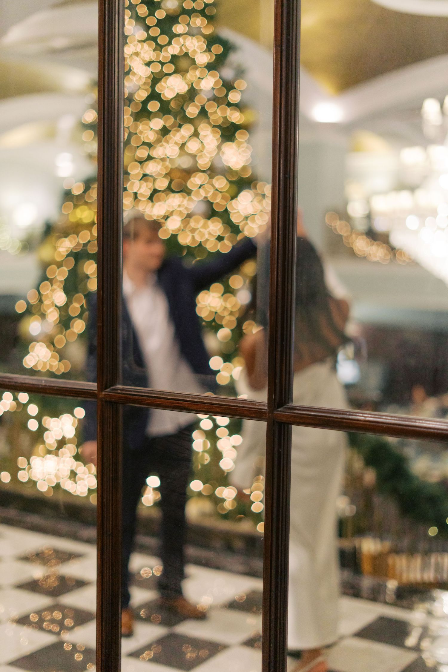 Elegant wedding venue reflection in window panes with Christmas decorations and twinkling lights.