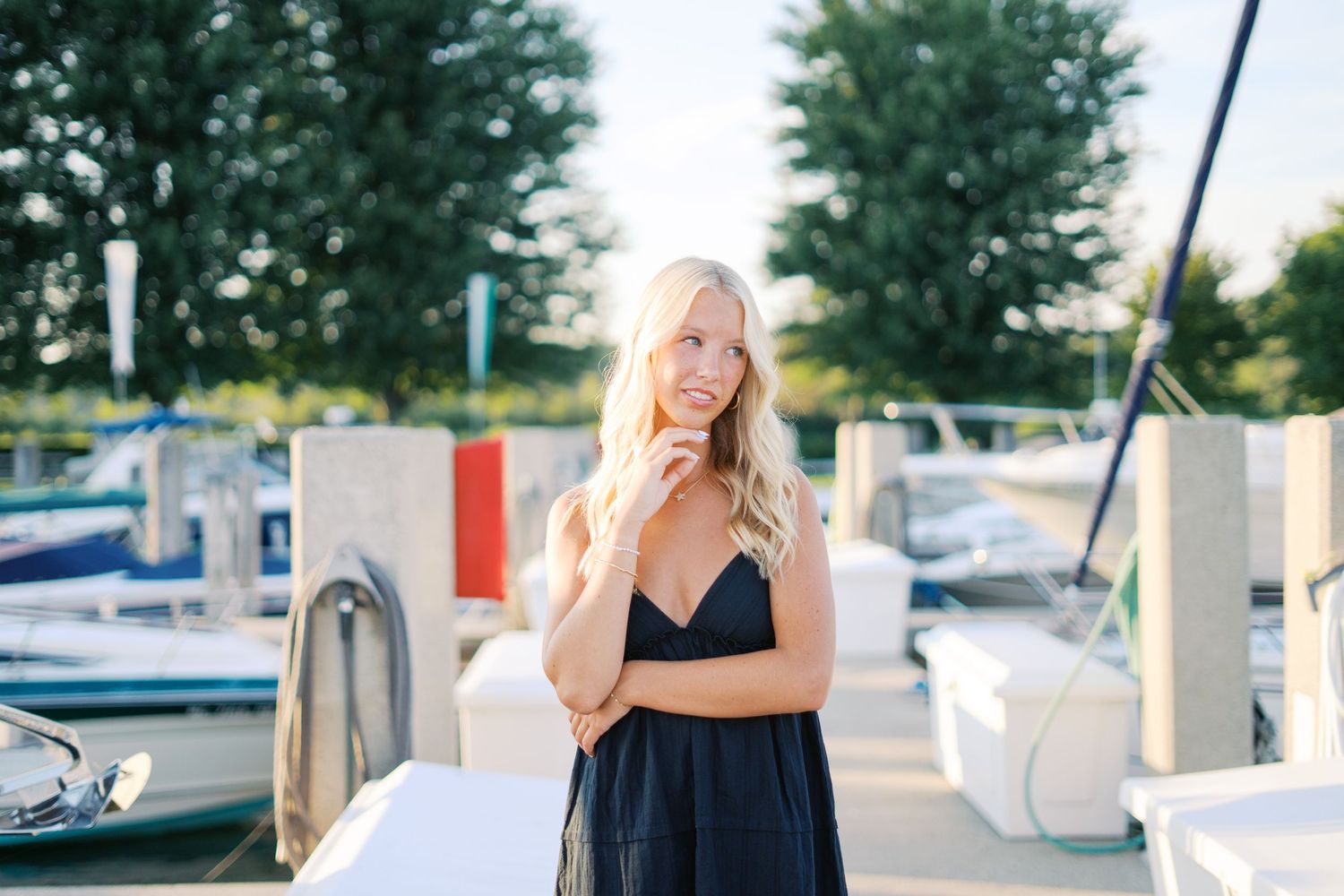 Summer photoshoot at marina with boats in background.
