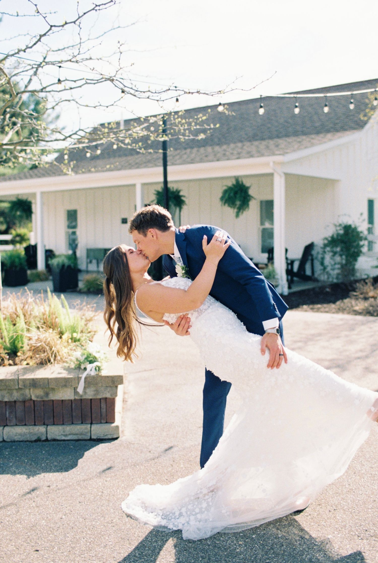 Romantic dance sequence shows couple in white dress and navy suit performing dramatic dip.