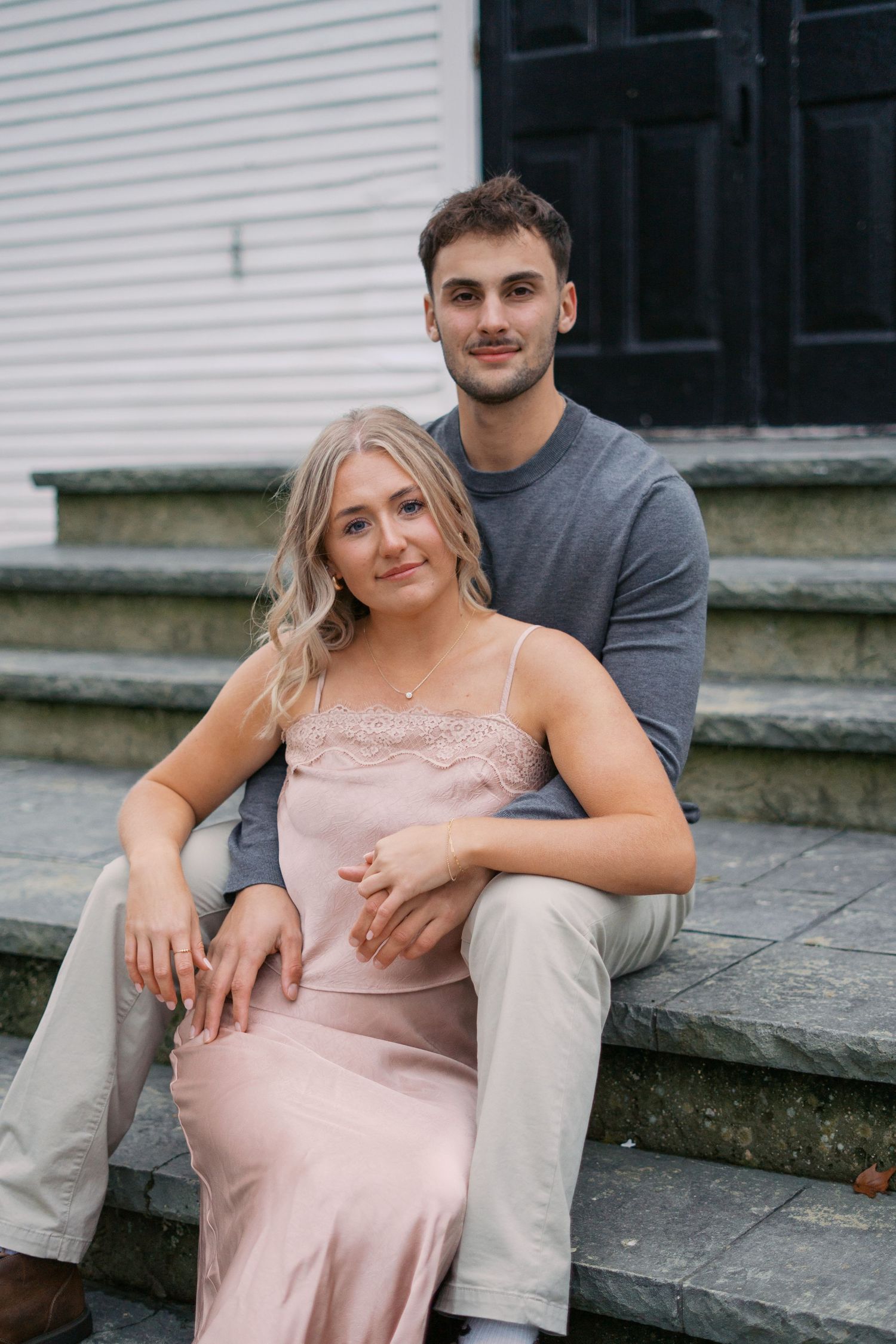 Couple sits together on stone steps during an outdoor photo session.