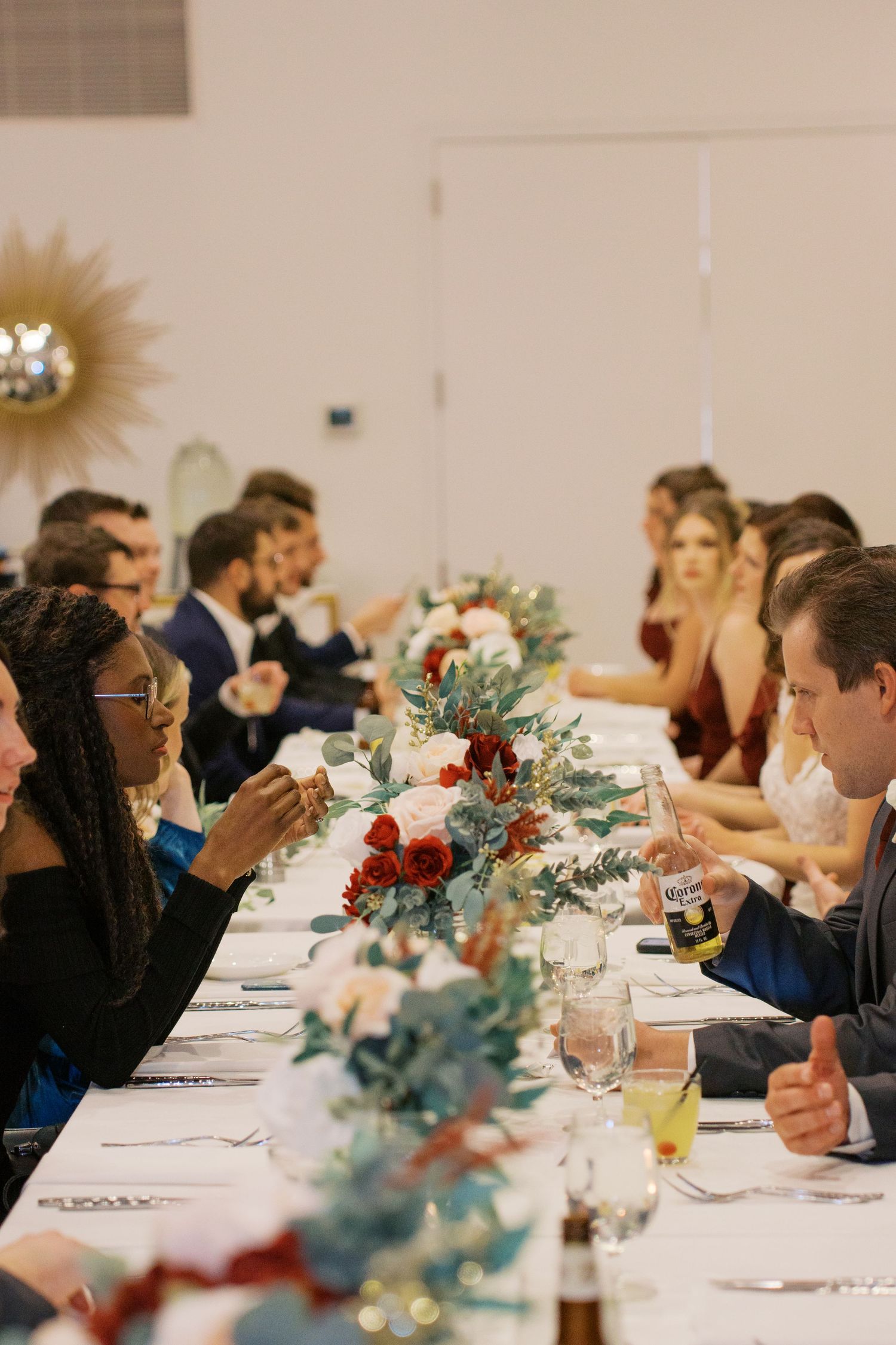 Wedding reception table decorated with elegant floral centerpieces and place settings.