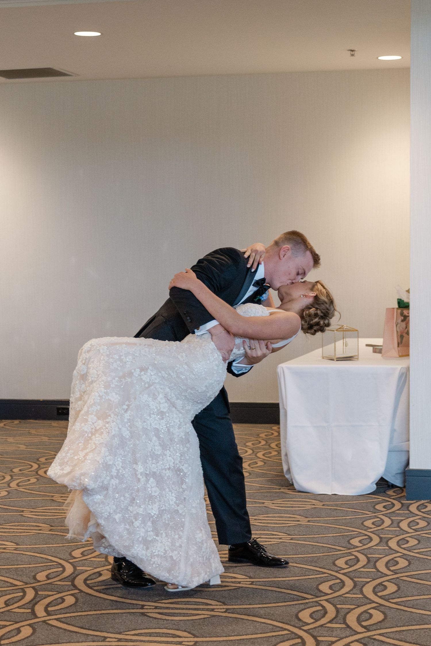 A romantic moment captured during a wedding reception with a classic dip pose.