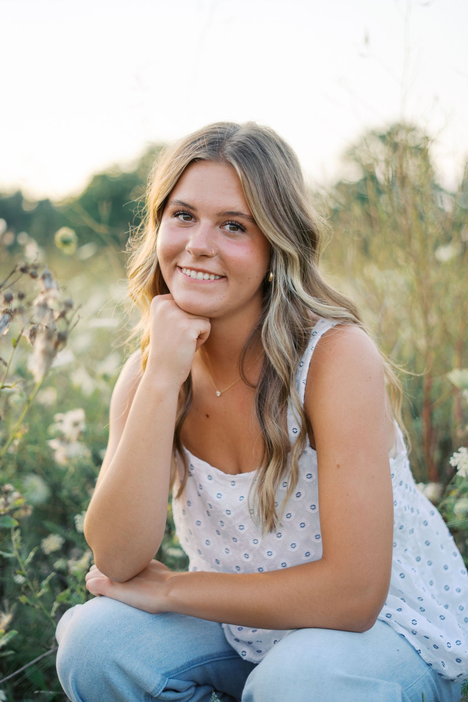 Relaxed outdoor portrait session with natural poses in a blooming wildflower meadow.