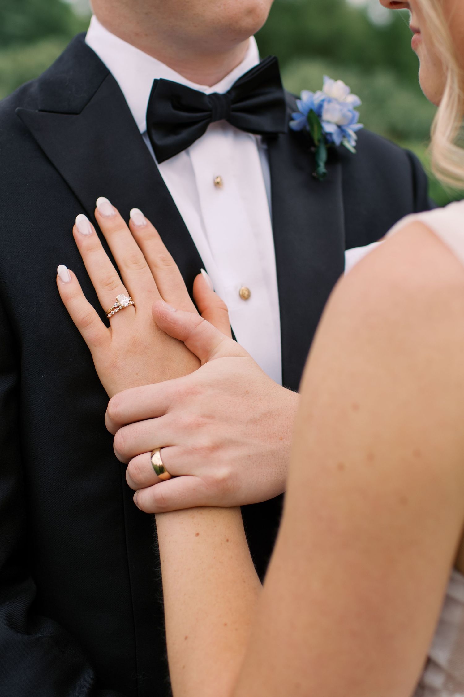 Close-up shots of wedding rings and hands showcasing the newlyweds' jewelry against formal attire.