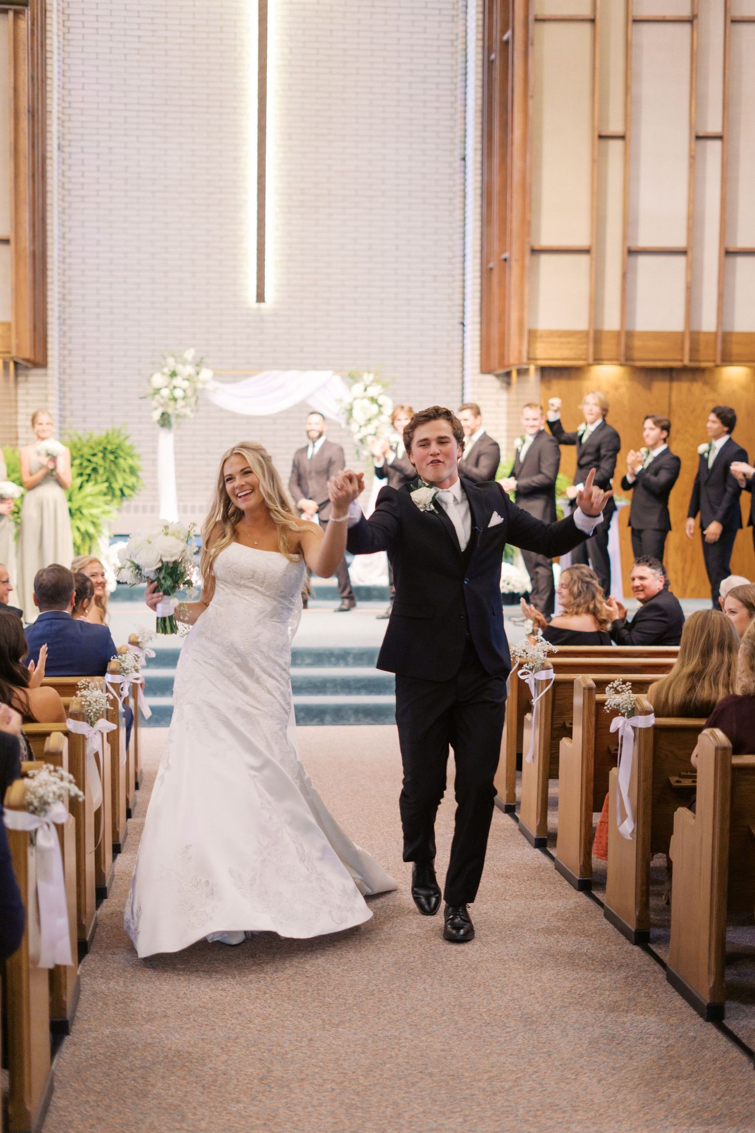 A wedding party performs choreographed dance moves in a church sanctuary.