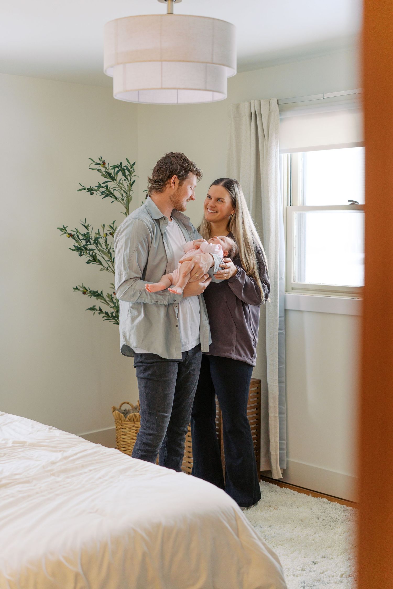 Family sharing intimate moment together in bright bedroom.