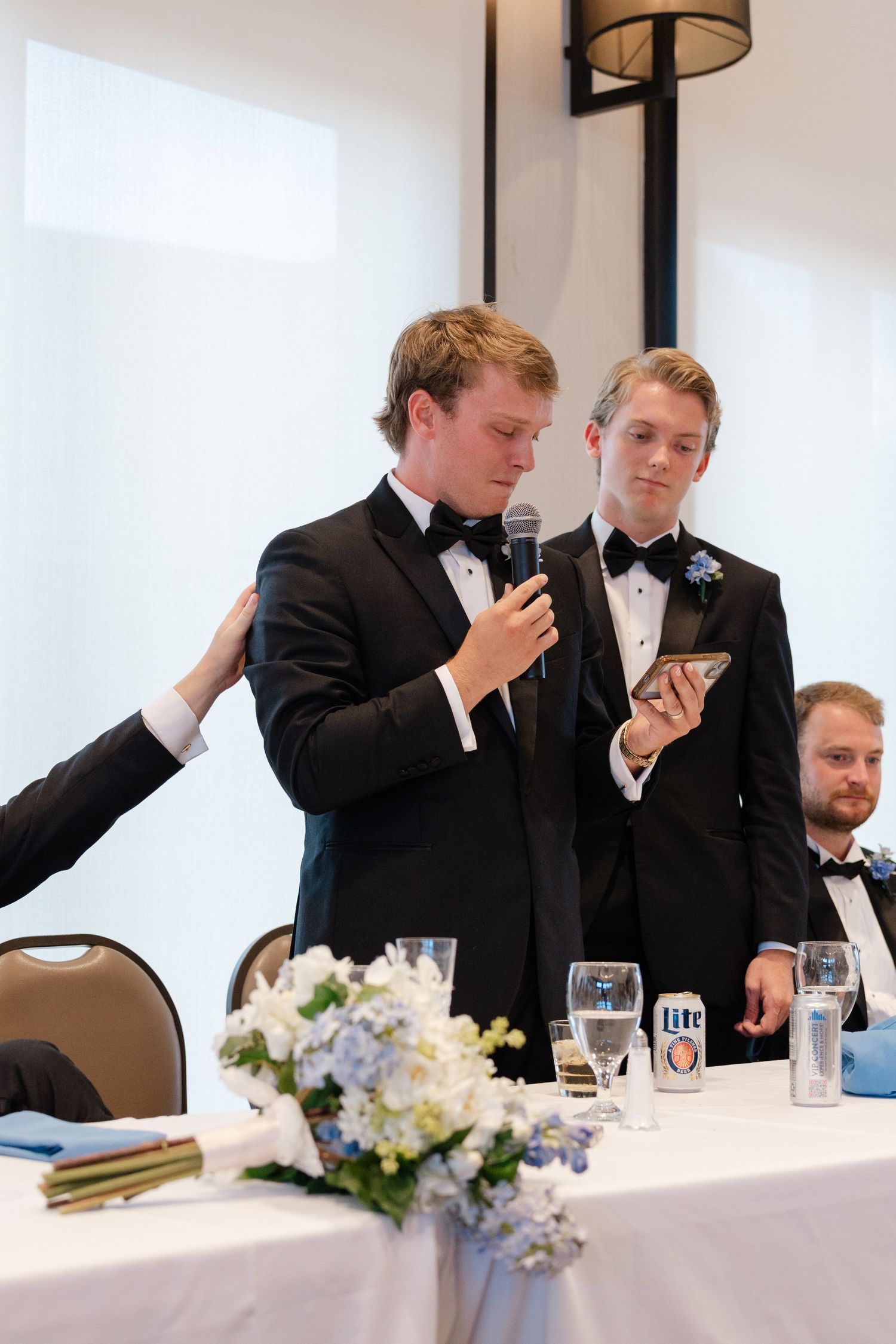 Formal speeches being given during wedding reception with elegant table decorations.