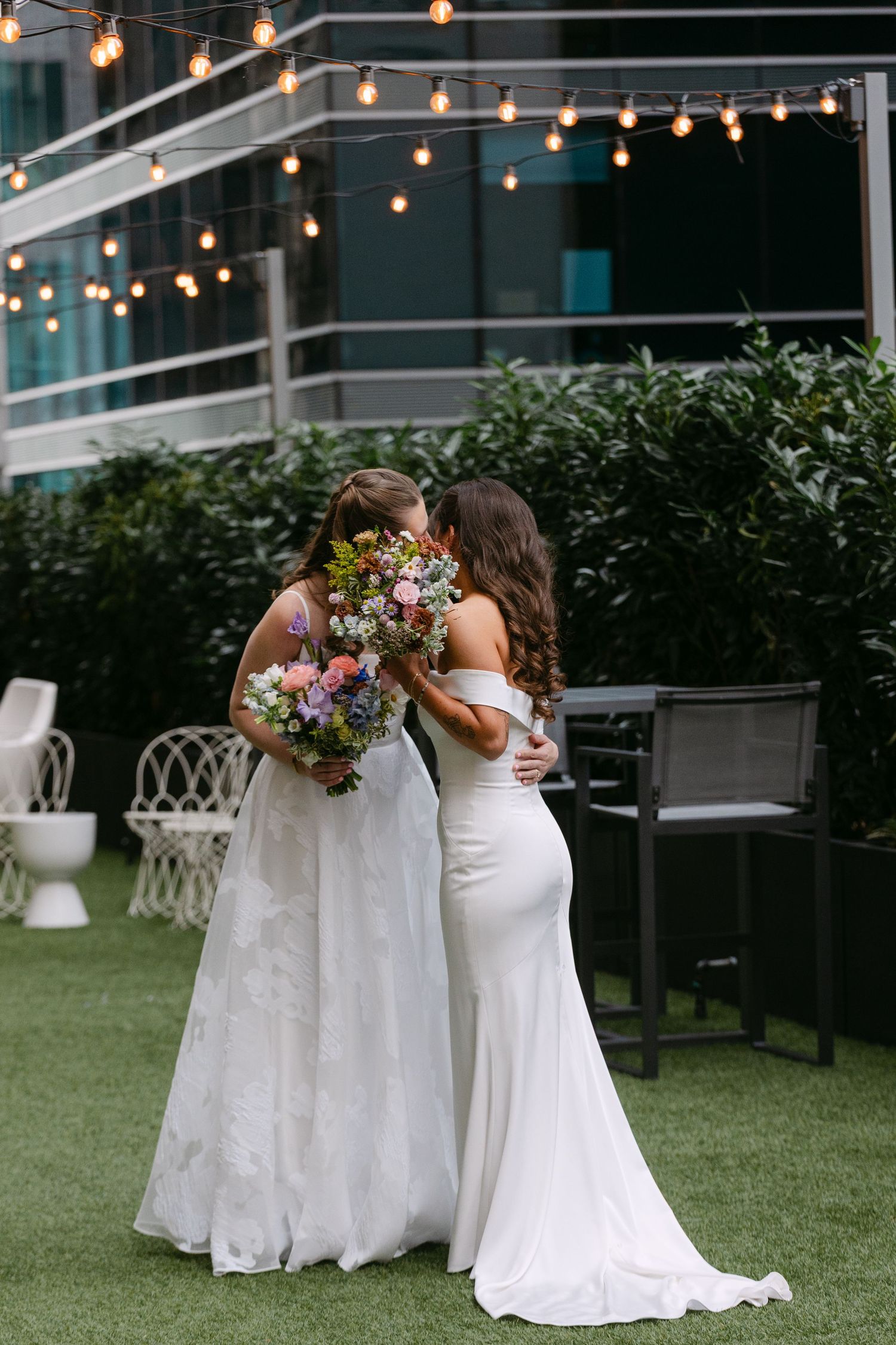 Three wedding photos show people in white dresses embracing outdoors under string lights on a grassy lawn.