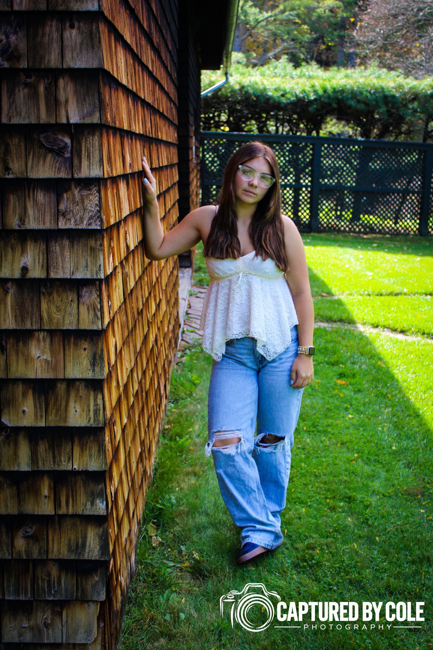 This is a picture of a girl leaning against a barn