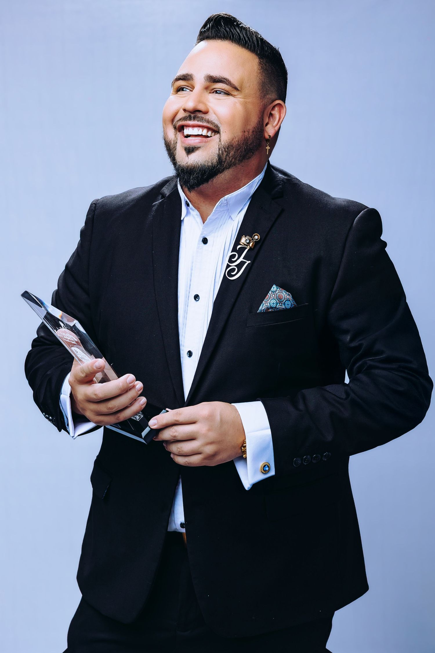 Professional photo series showing person in black tuxedo holding mobile phone against light blue background.