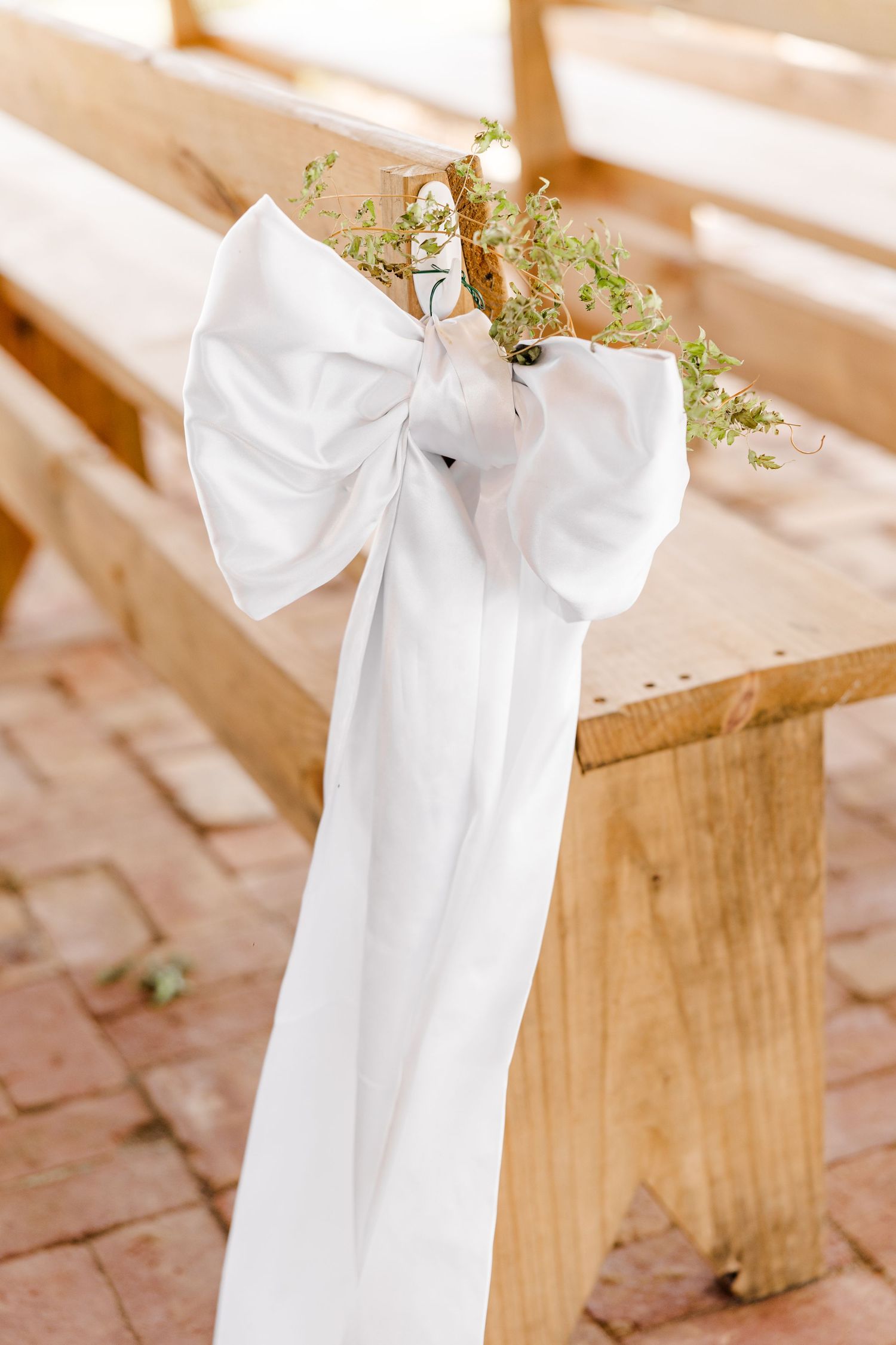 White fabric draping decorates wooden ceremony chairs.