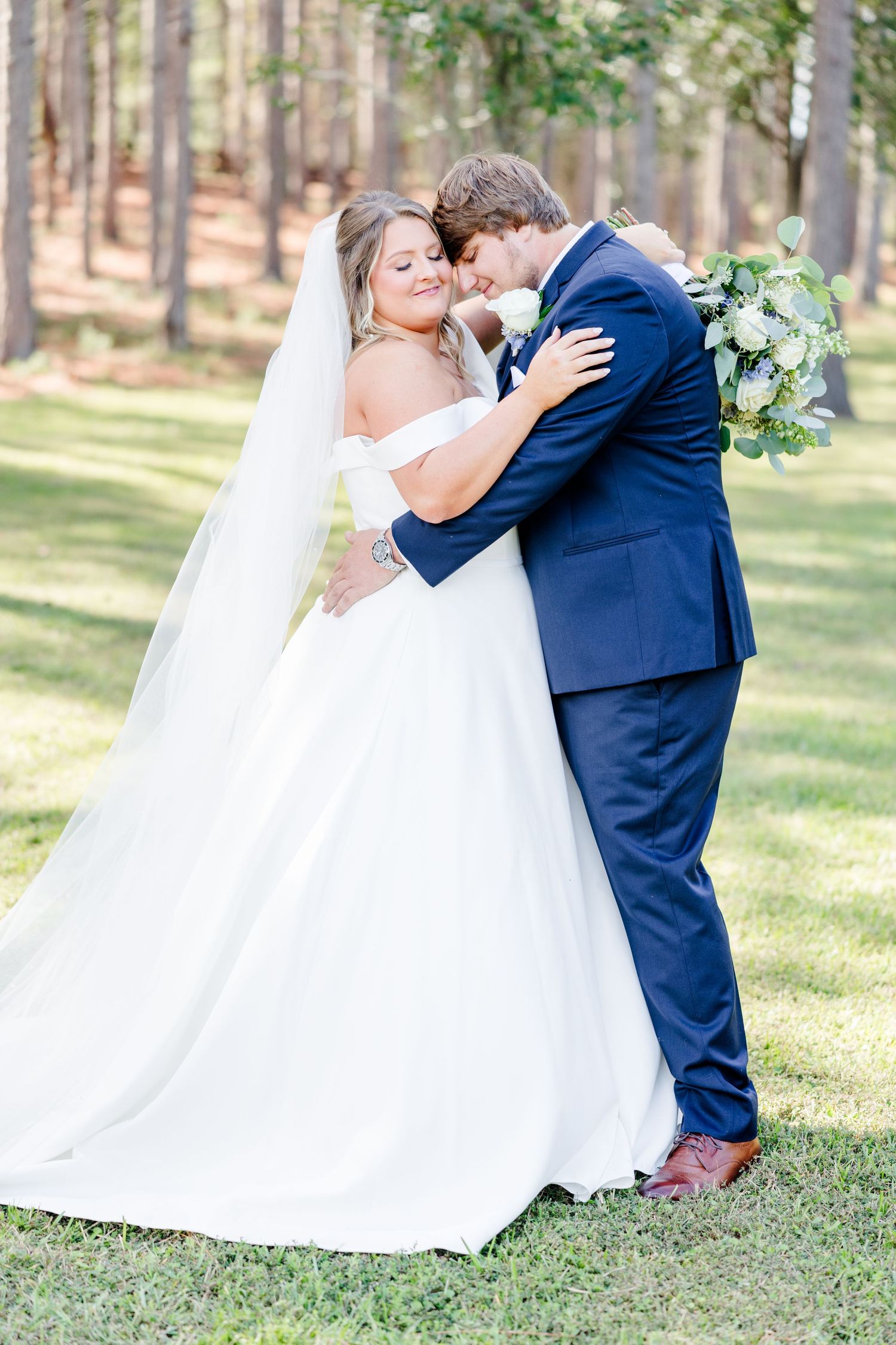 Newlyweds embrace during romantic outdoor wedding photo session.