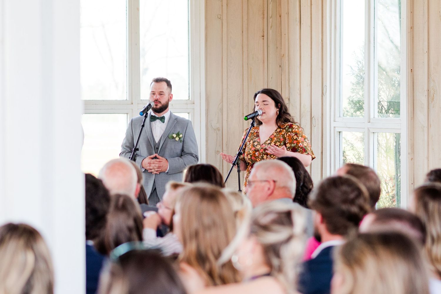 Wedding guests watch the ceremony proceedings inside a light-filled chapel venue.