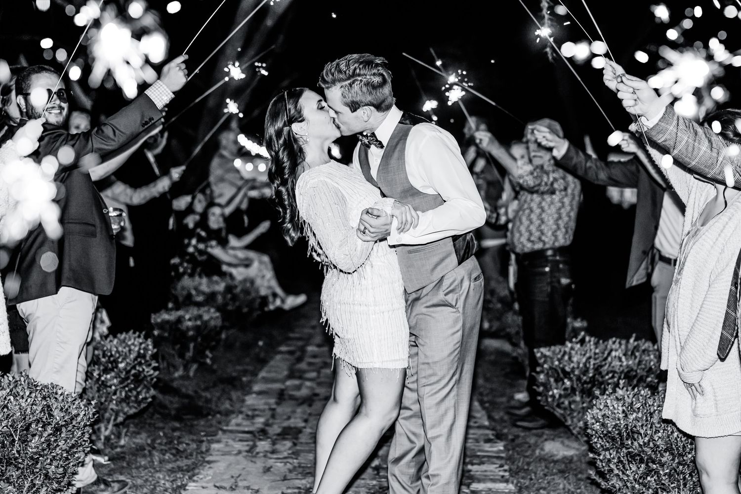 Black and white photo of a couple's sparkler exit at their wedding celebration.