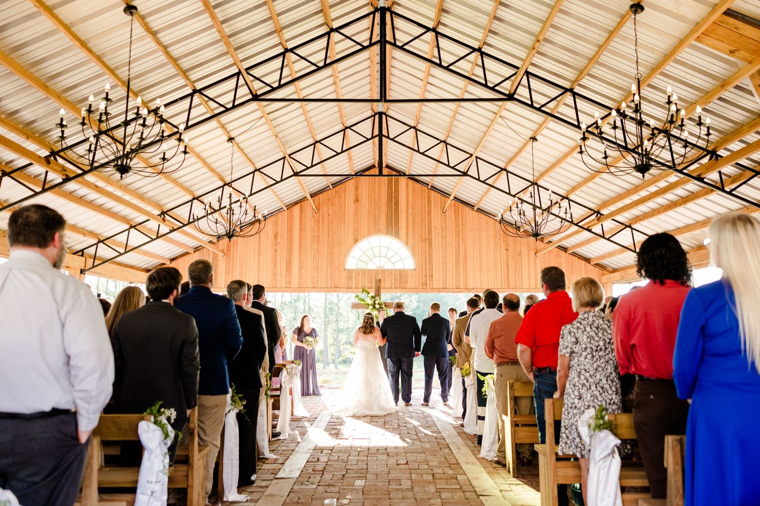 Interior view of a wedding venue with exposed wooden beams and trusses.