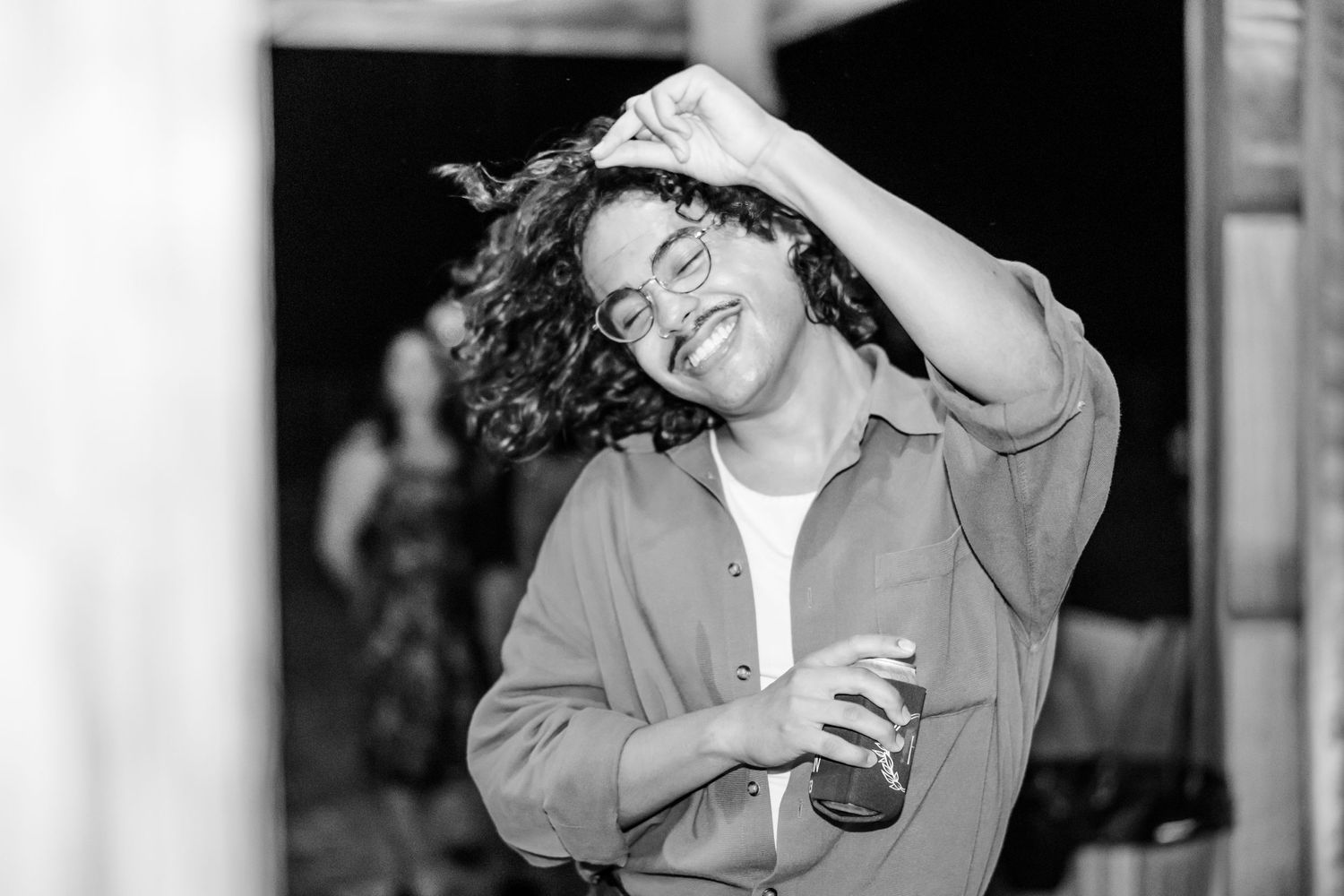 Black and white photo of guests enjoying themselves at a lively wedding reception.