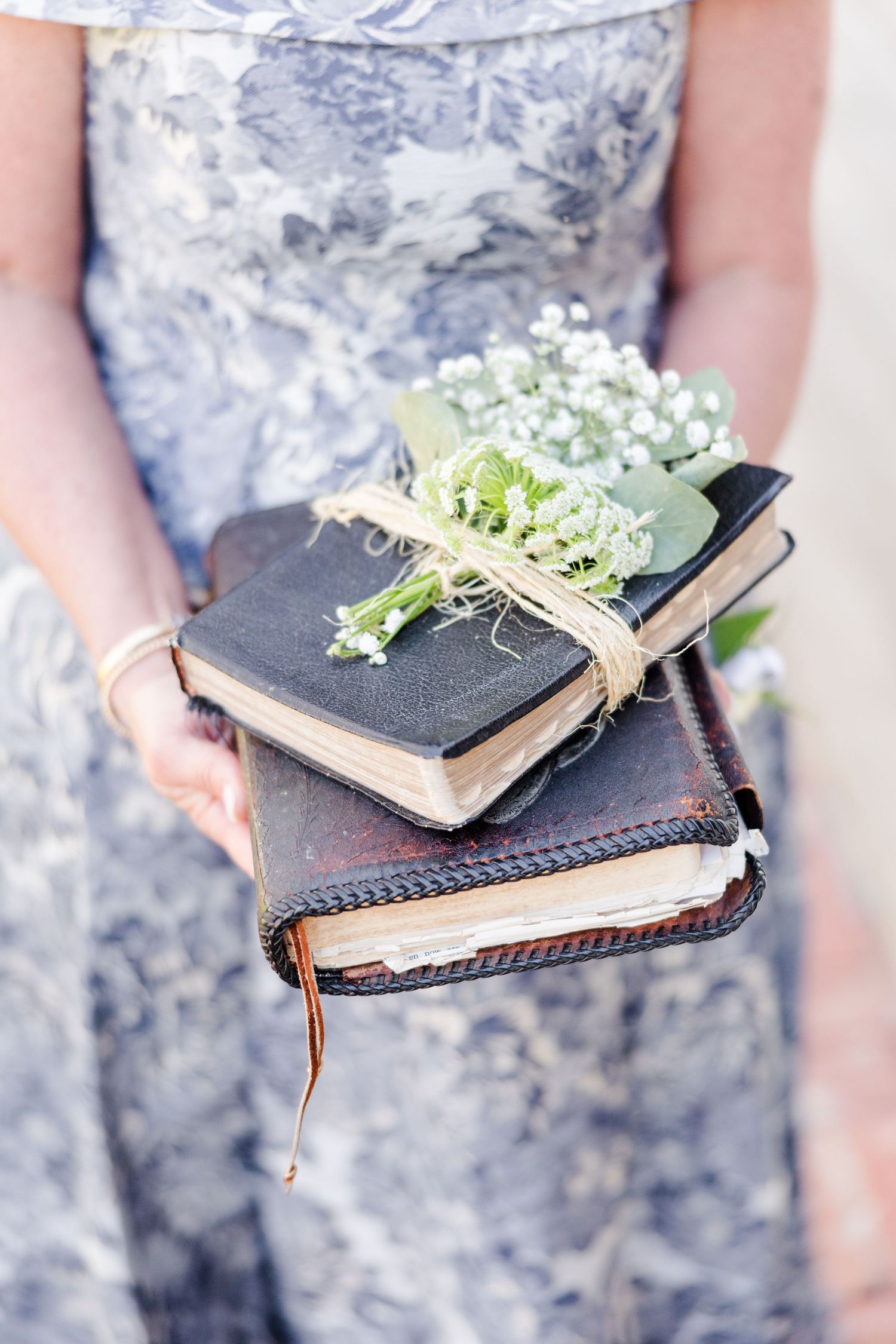 Vintage books decorated with delicate white flowers and twine.