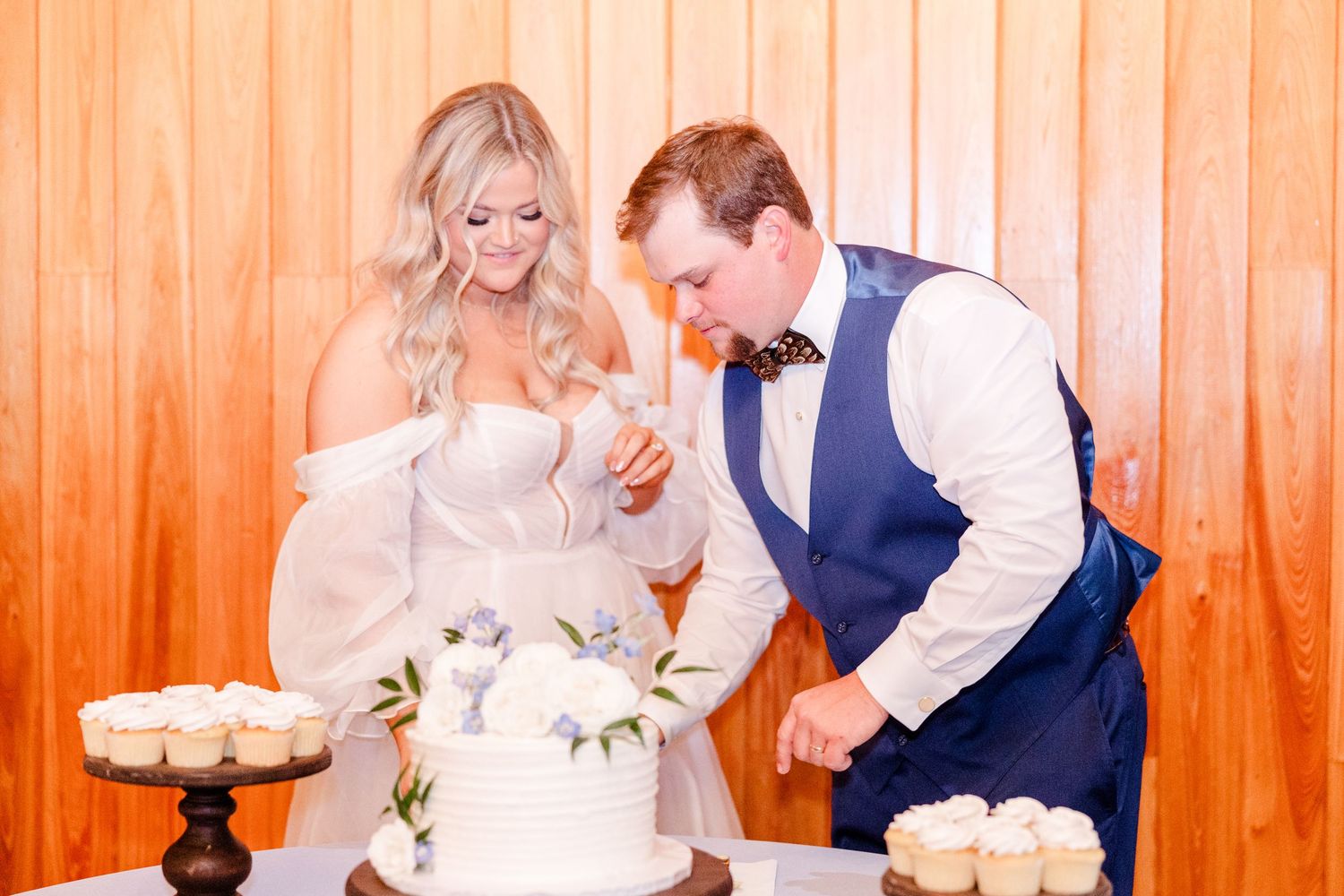 Joyful wedding reception dance party with orange wood paneled walls in background.