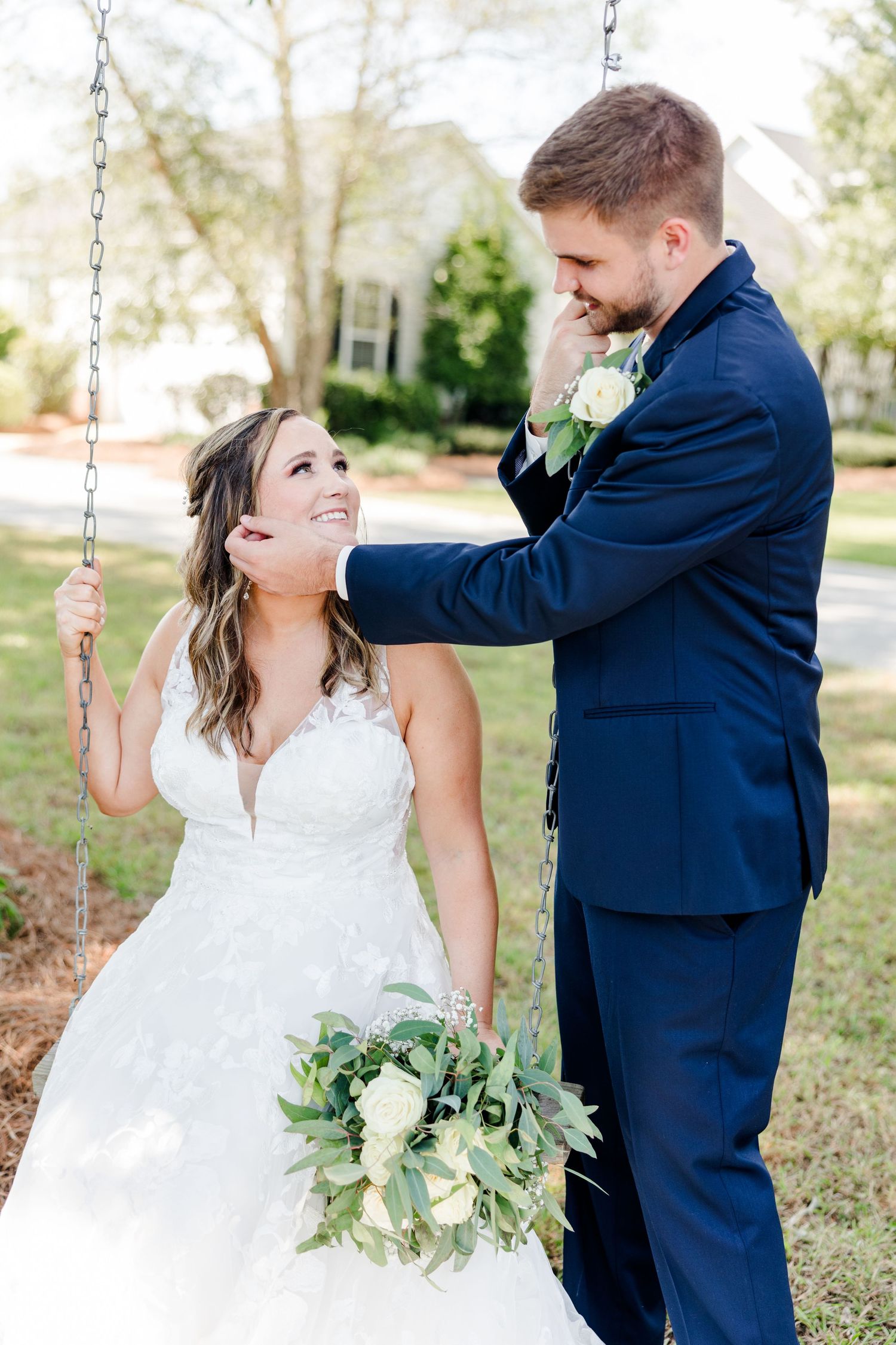 Bride and groom share playful moments on a swing set during their wedding photoshoot.