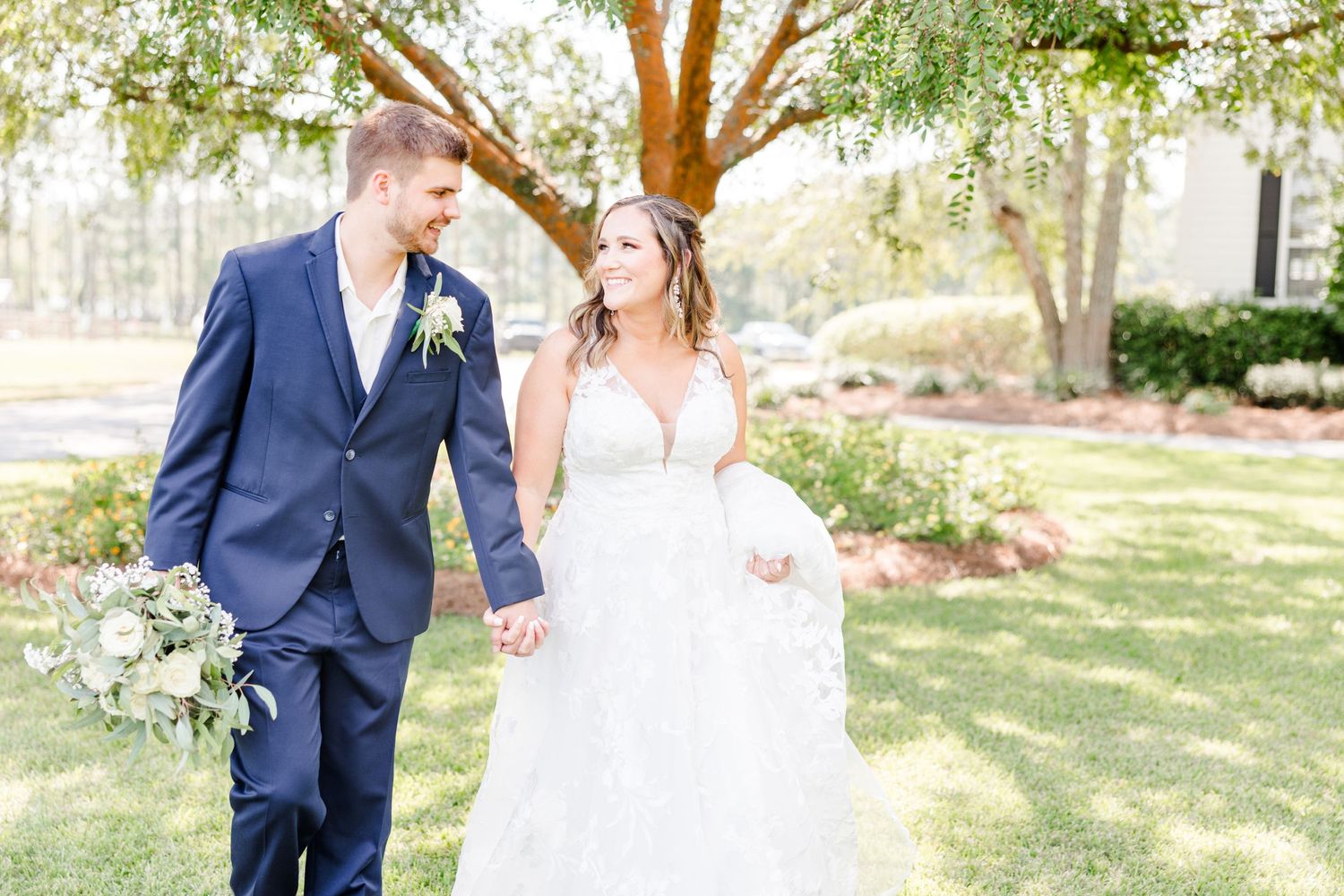 Sunlit garden wedding portraits showcase classic bride and groom attire with natural backdrop.