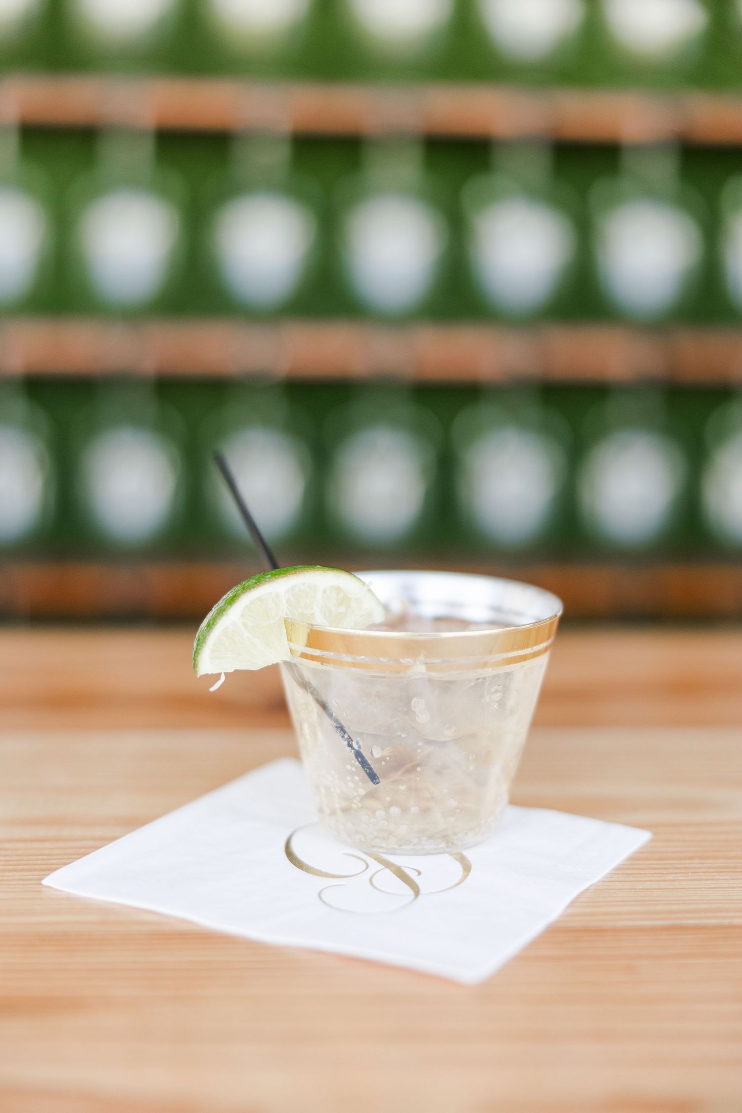 Clear glass margarita glasses arranged on white paper on wooden surface.