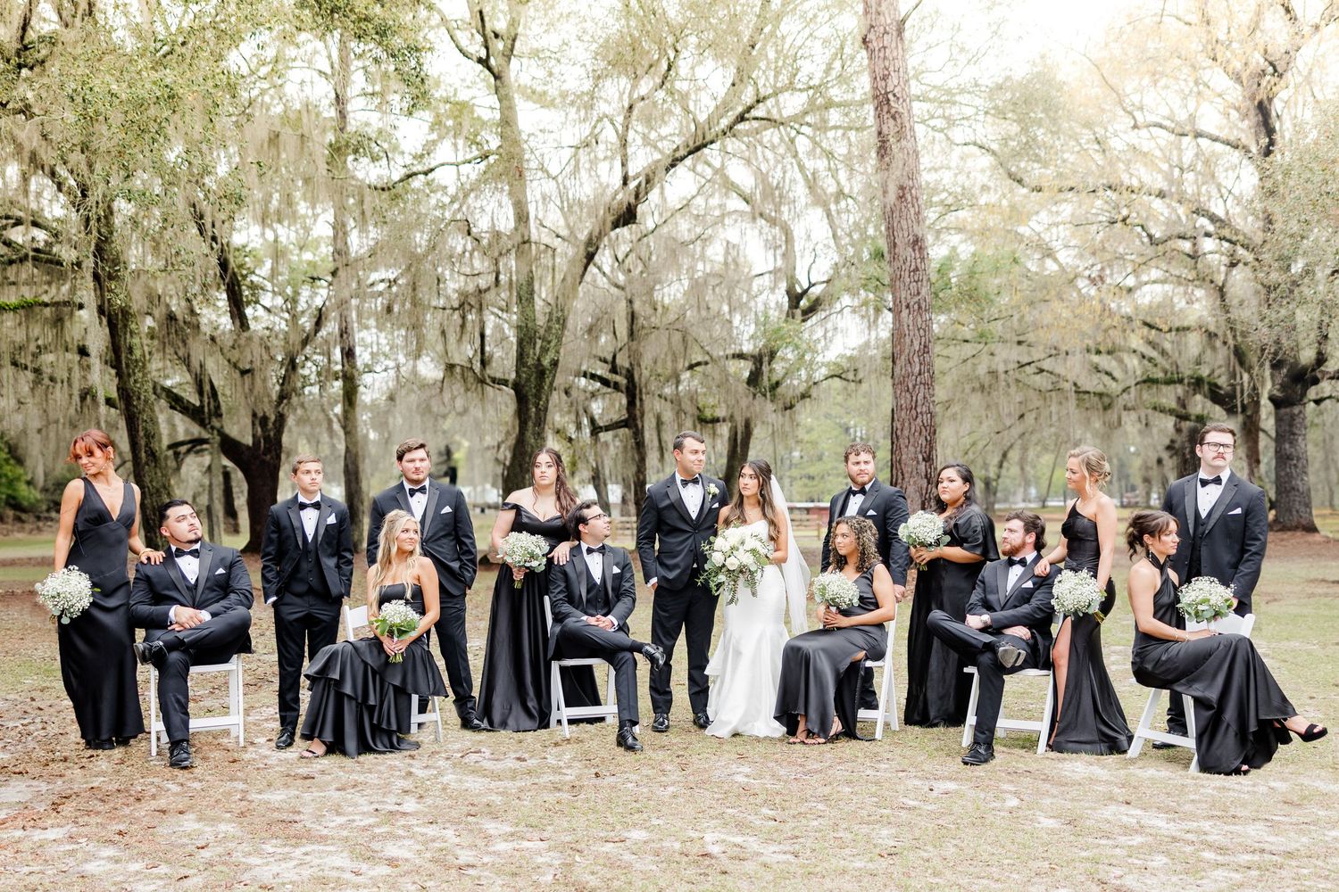 Wedding party members gather for candid moments in natural outdoor setting.