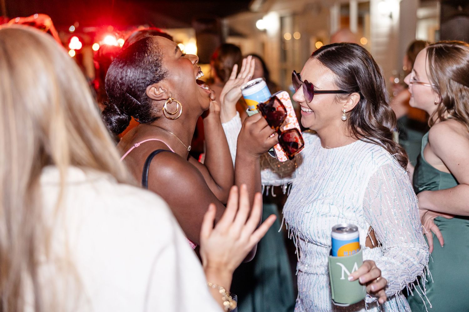 Wedding guests enjoying drinks and celebrating at an evening reception party.