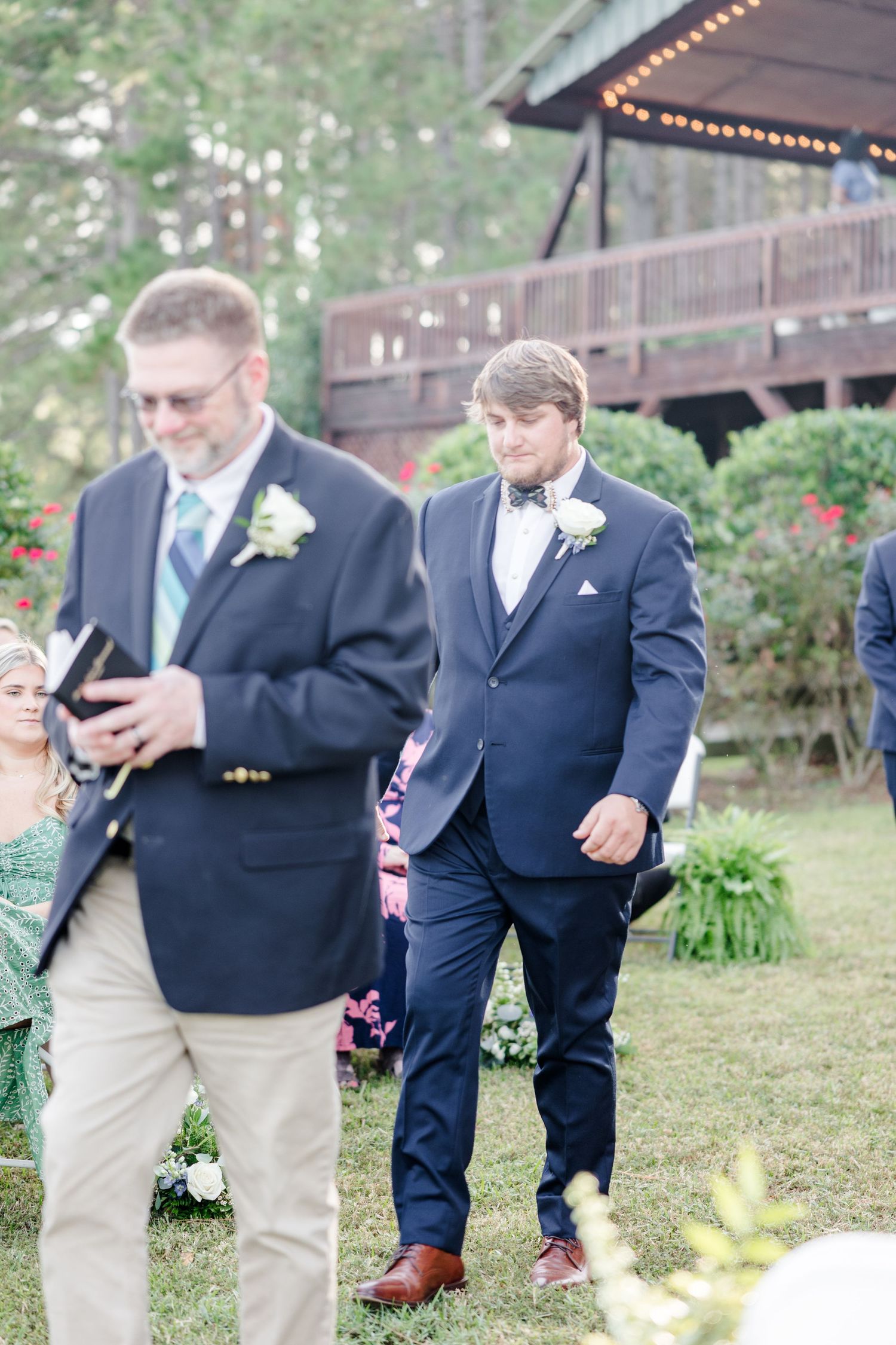 Groomsmen in navy suits gather informally before the wedding ceremony.