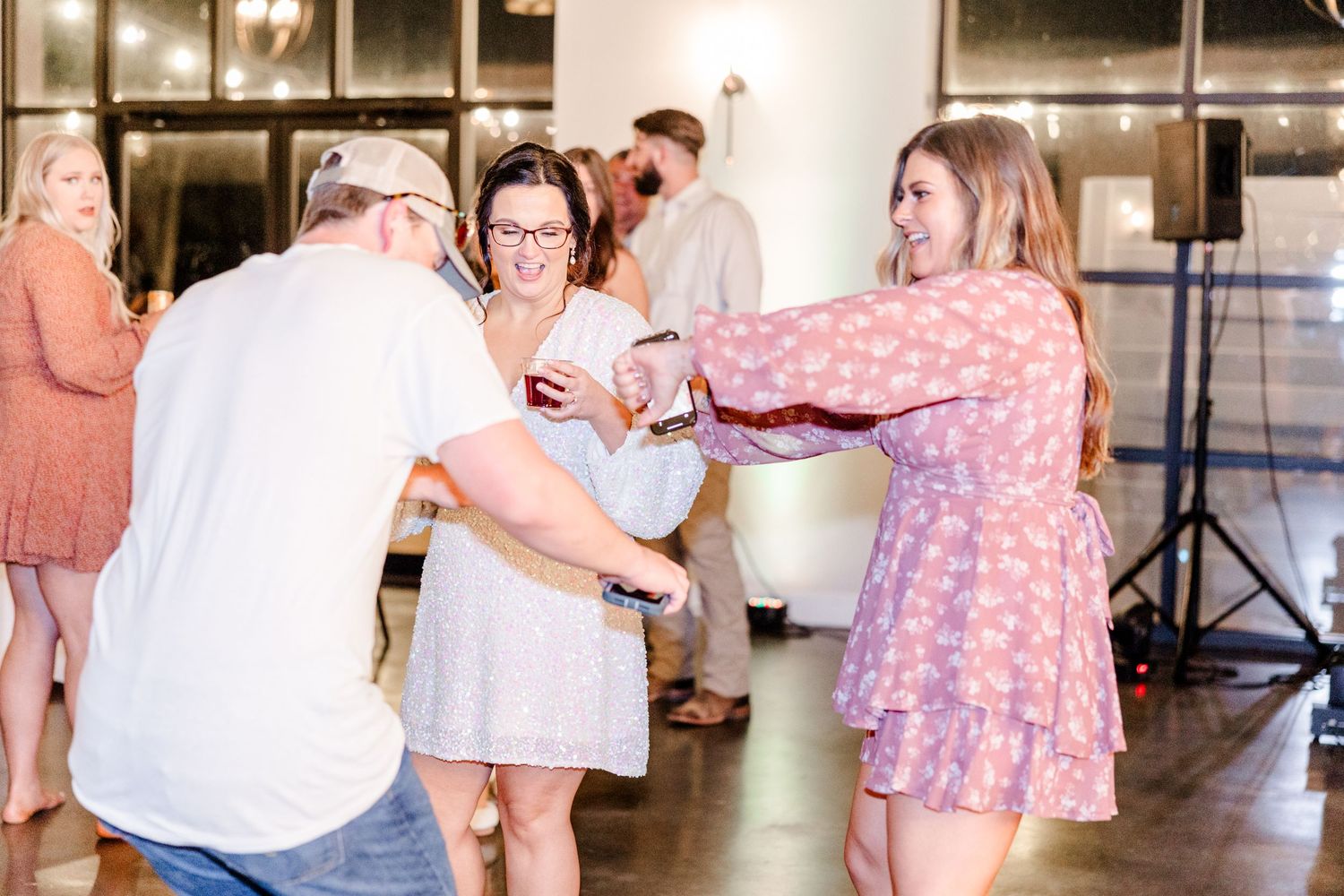 Wedding guests dancing and celebrating in a modern reception venue.