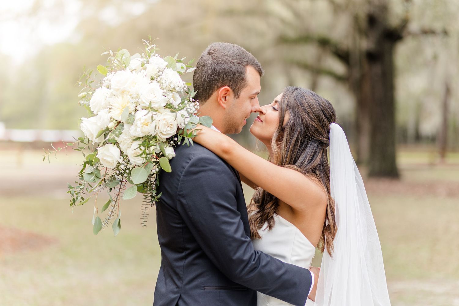 Intimate wedding couple portraits showing tender moments and elegant white floral details.