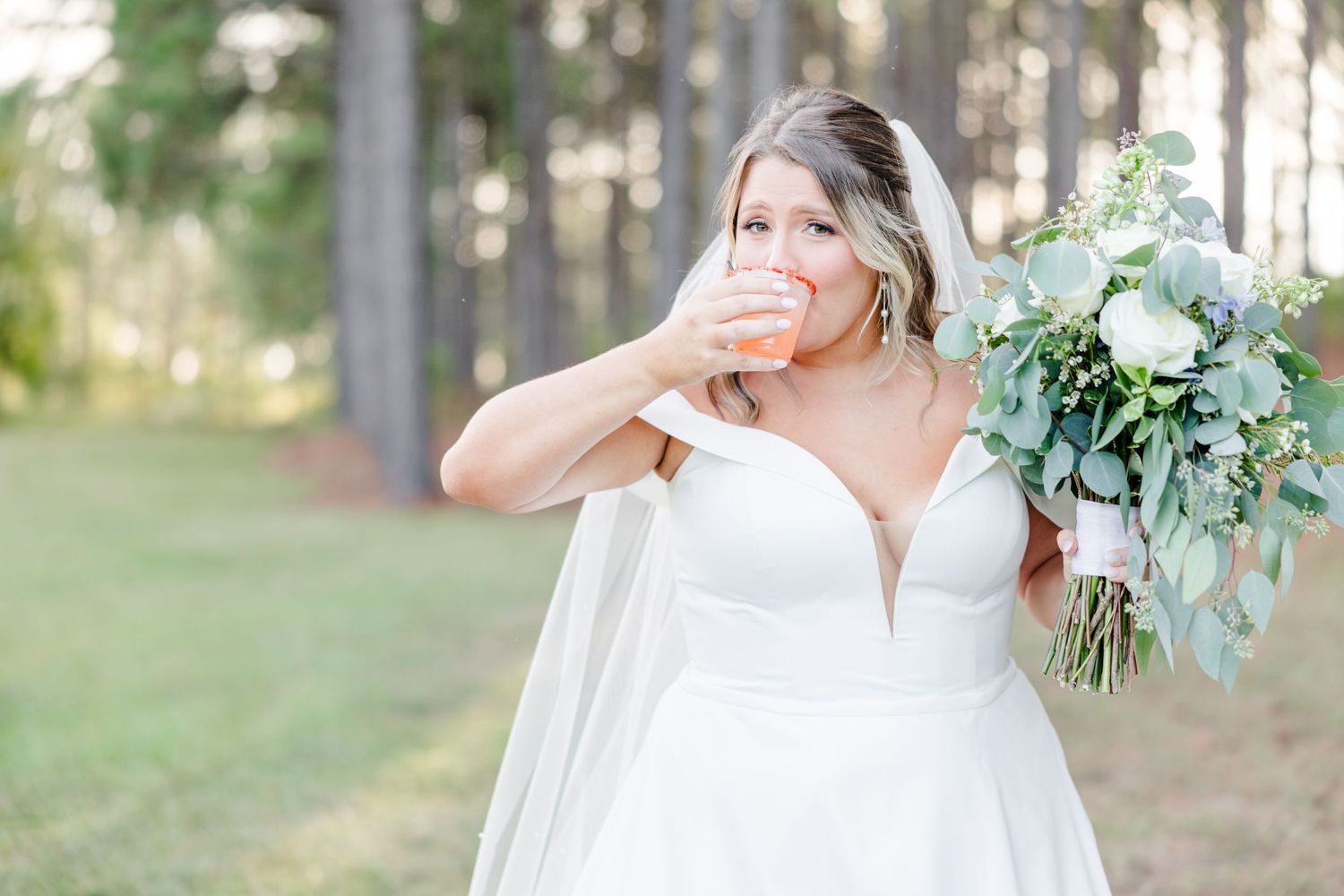 Newlyweds pose for romantic portraits in a wooded outdoor setting.
